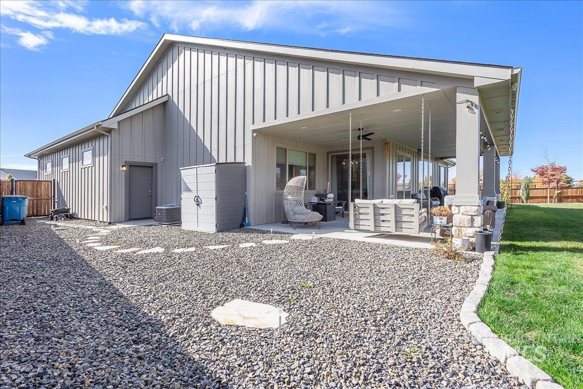 View of front of house featuring board and batten siding, a ceiling fan, an outdoor living space, and a patio area