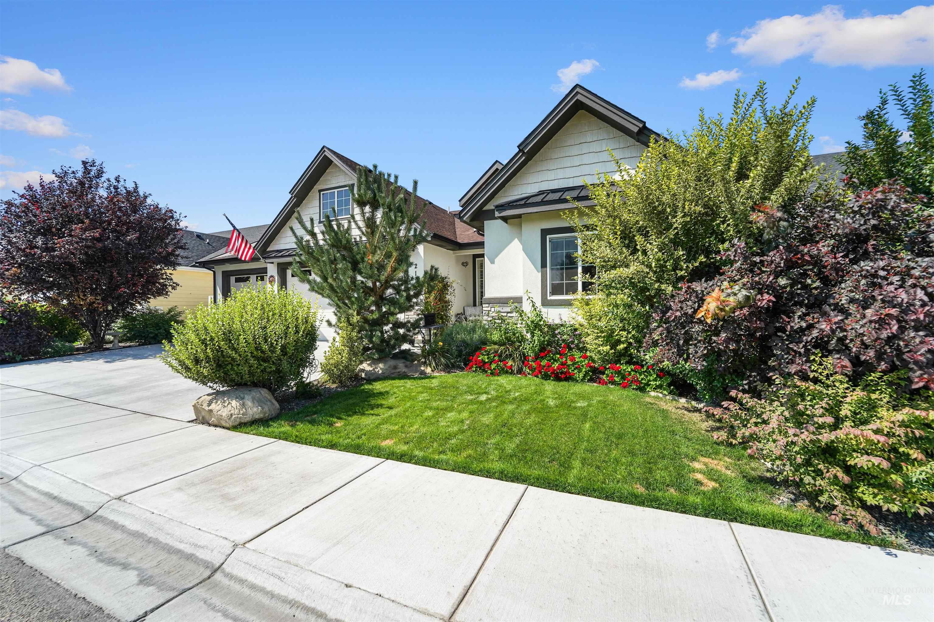 View of front of house with a front yard, stucco siding, and a garage