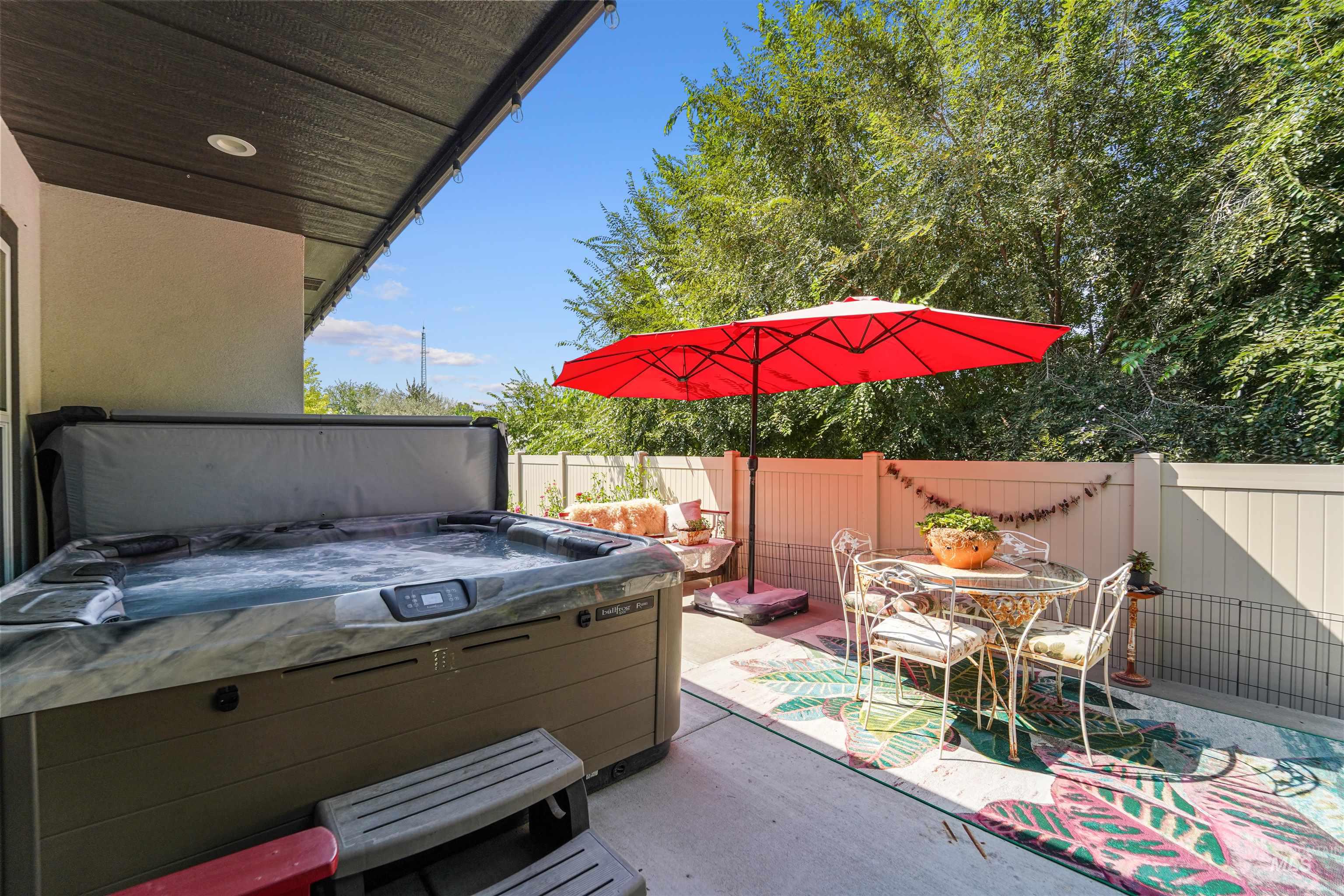 Fenced backyard with a patio and a hot tub