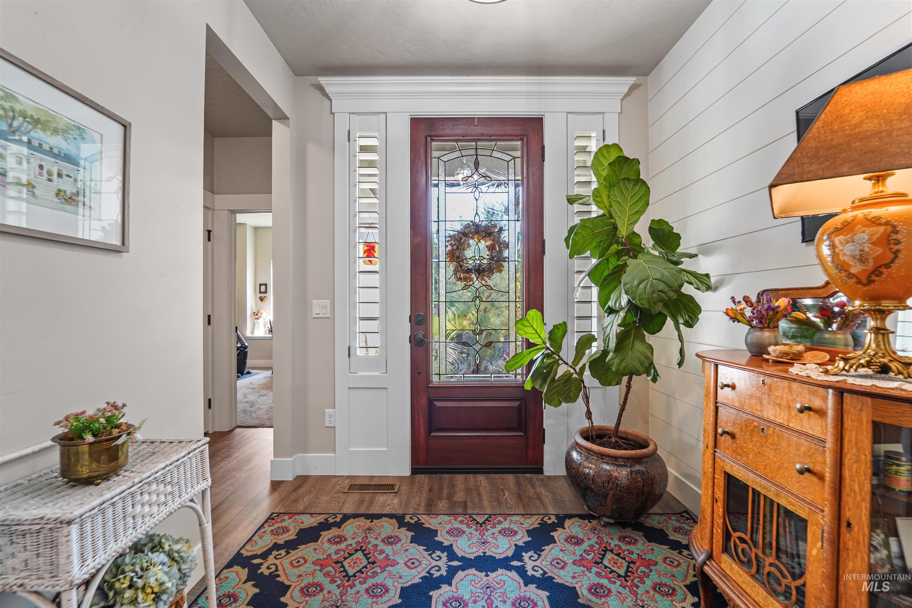 Entryway with dark wood-style flooring and wood walls