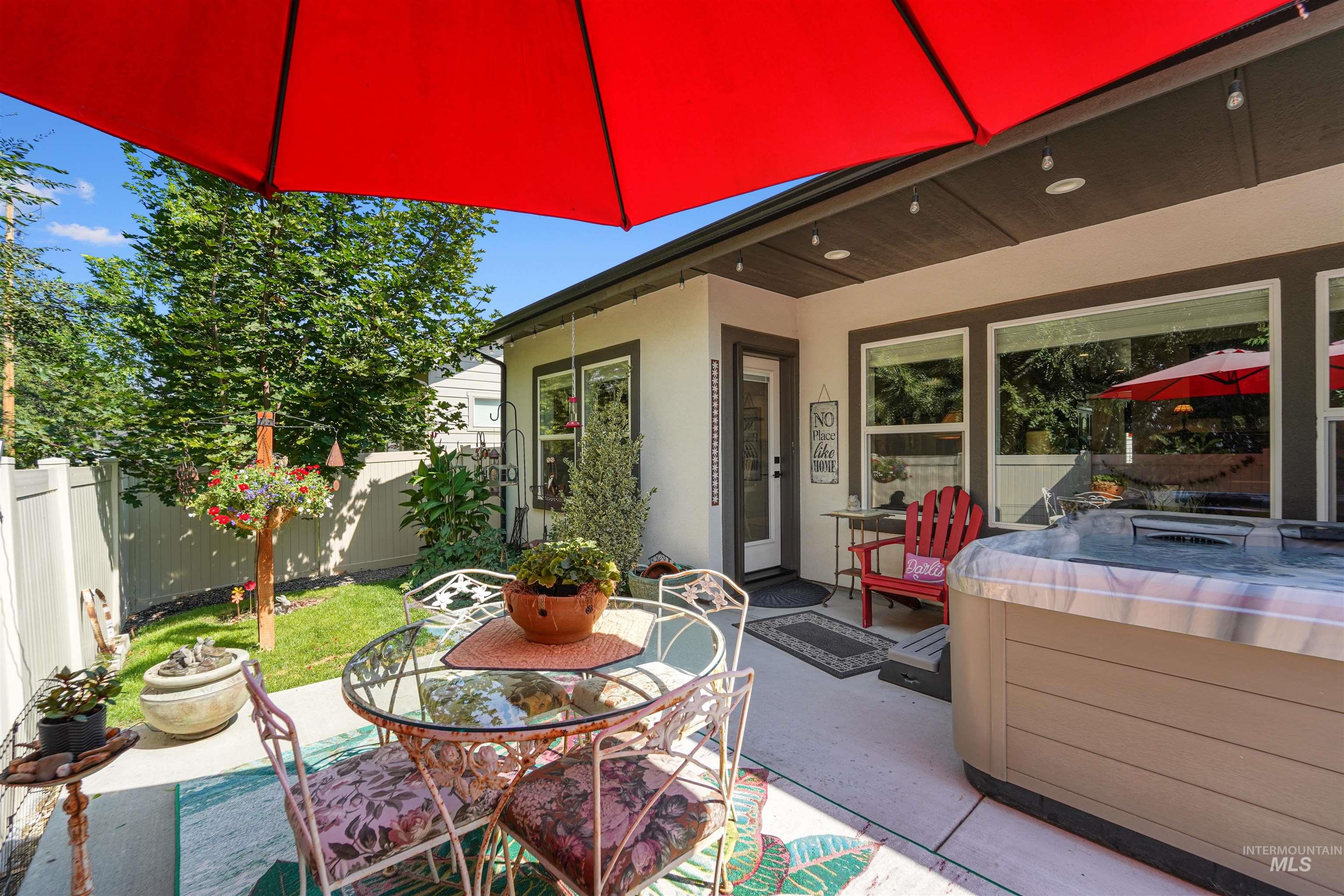 Fenced backyard featuring a hot tub, a patio, and outdoor dining space
