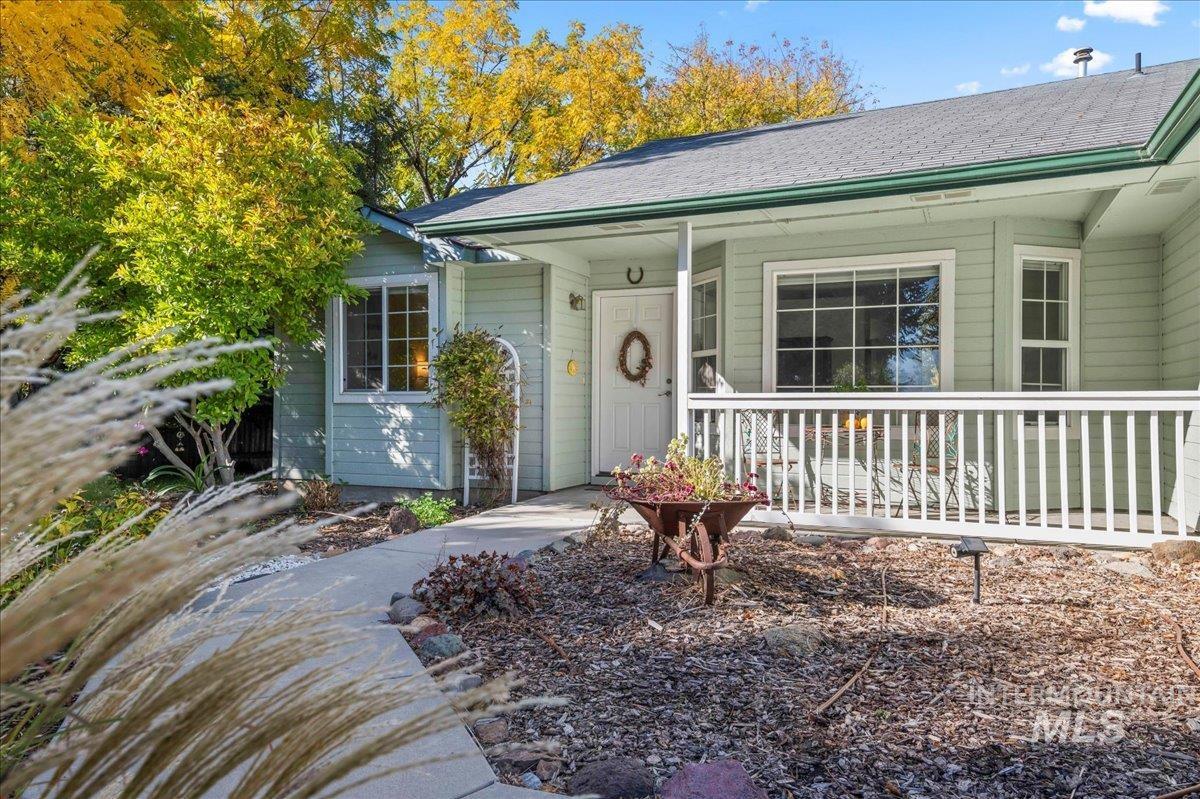Entrance to property with covered porch and roof with shingles