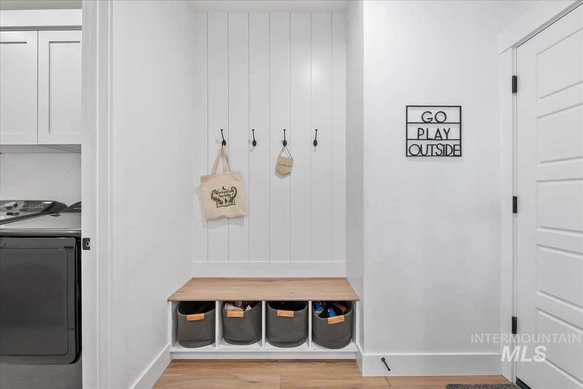Mudroom featuring light wood-style floors and separate washer and dryer