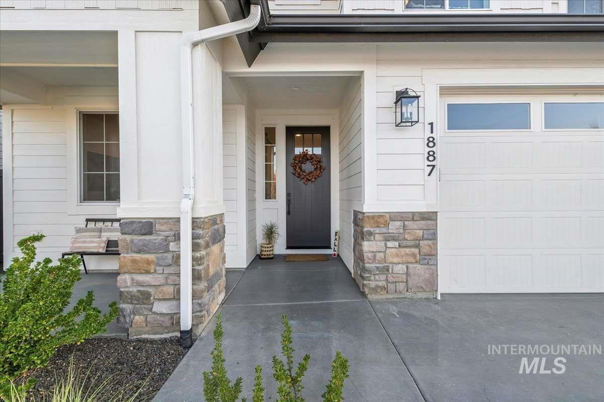Property entrance featuring a garage and stone siding