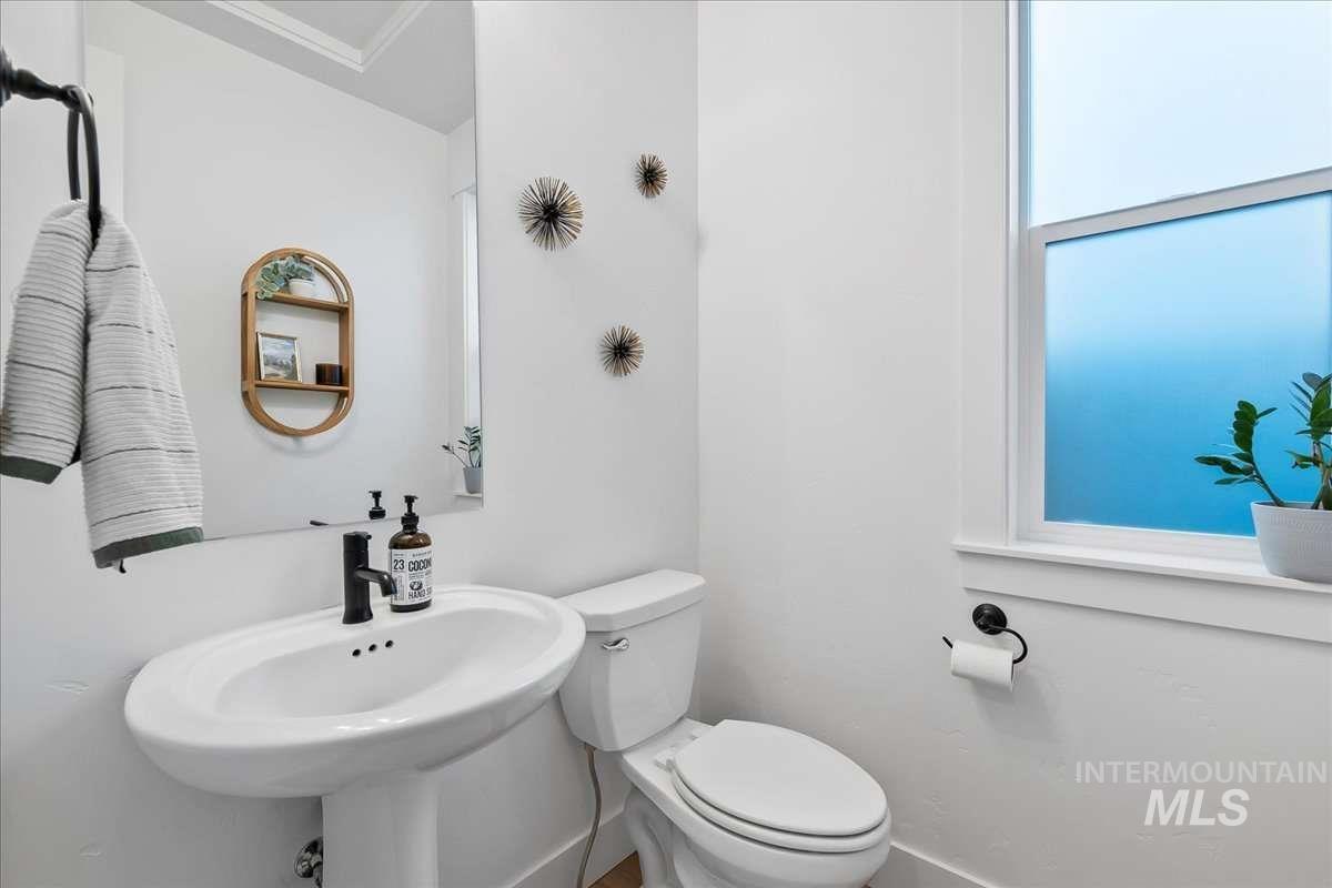 Half bath featuring toilet and baseboards