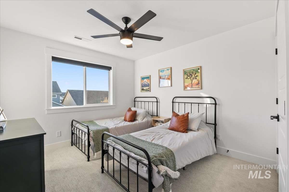 Bedroom featuring light colored carpet and a ceiling fan