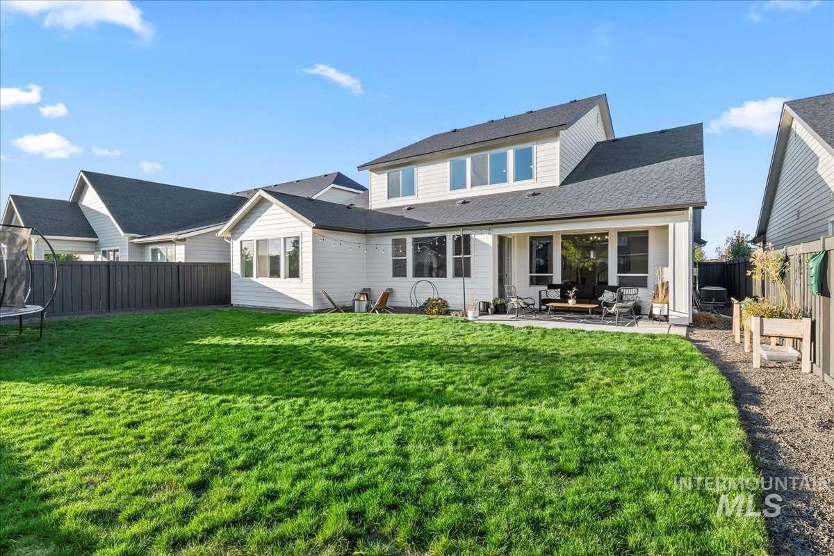 Back of property featuring a trampoline, a fenced backyard, and a patio