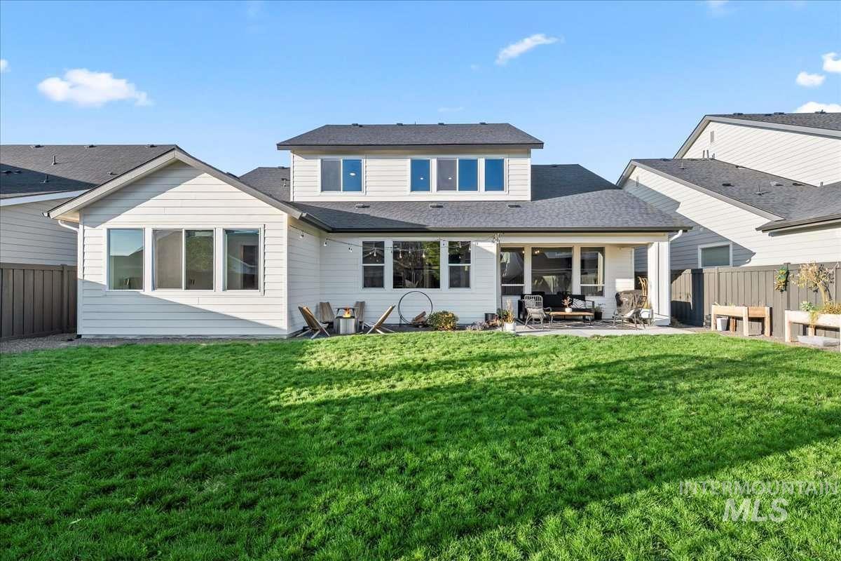 Back of property featuring a fenced backyard, a patio, and roof with shingles