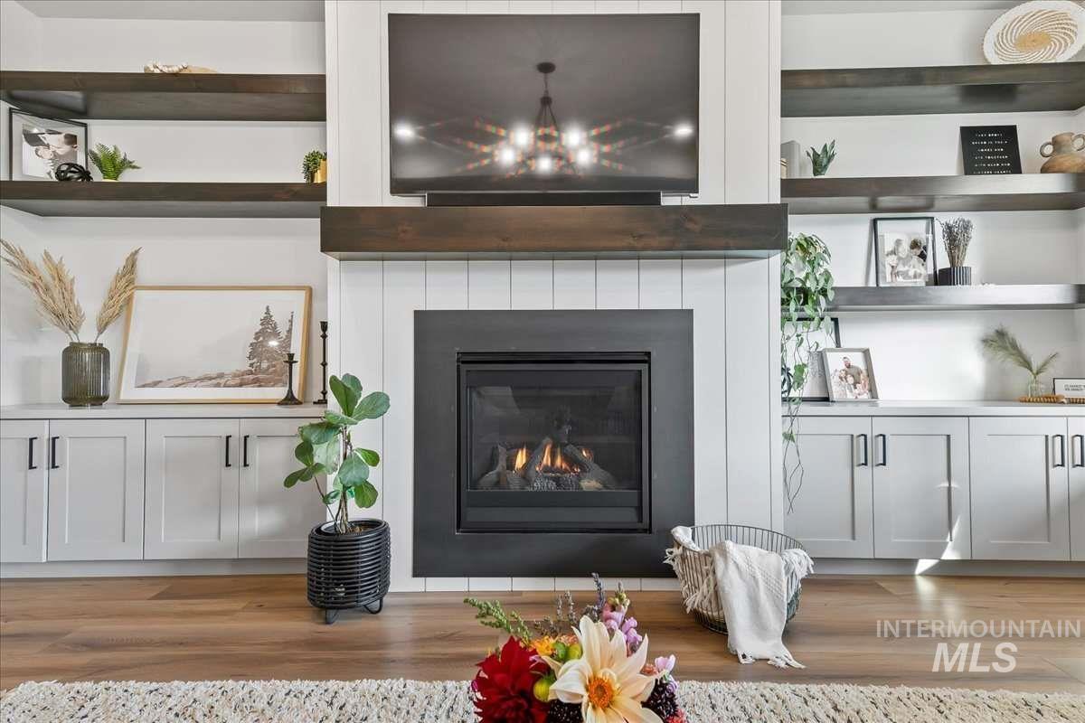Detailed view of a glass covered fireplace and wood finished floors