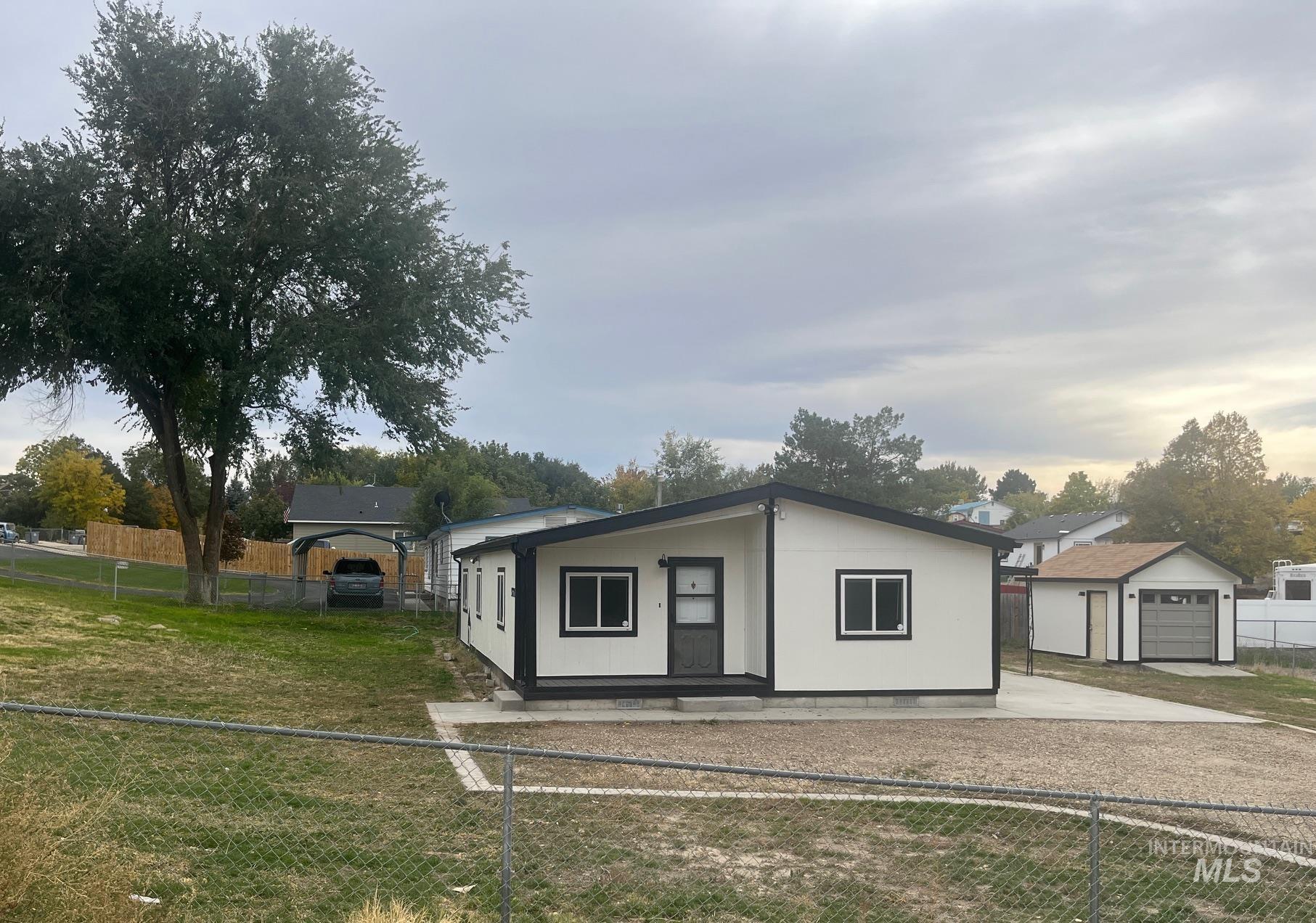 View of front of property featuring a patio area and an outdoor structure