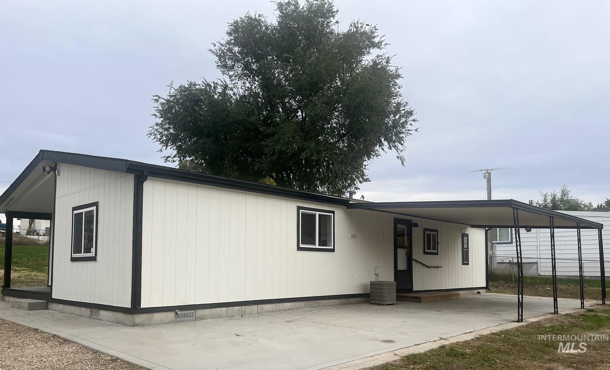 Manufactured / mobile home featuring a carport and concrete driveway