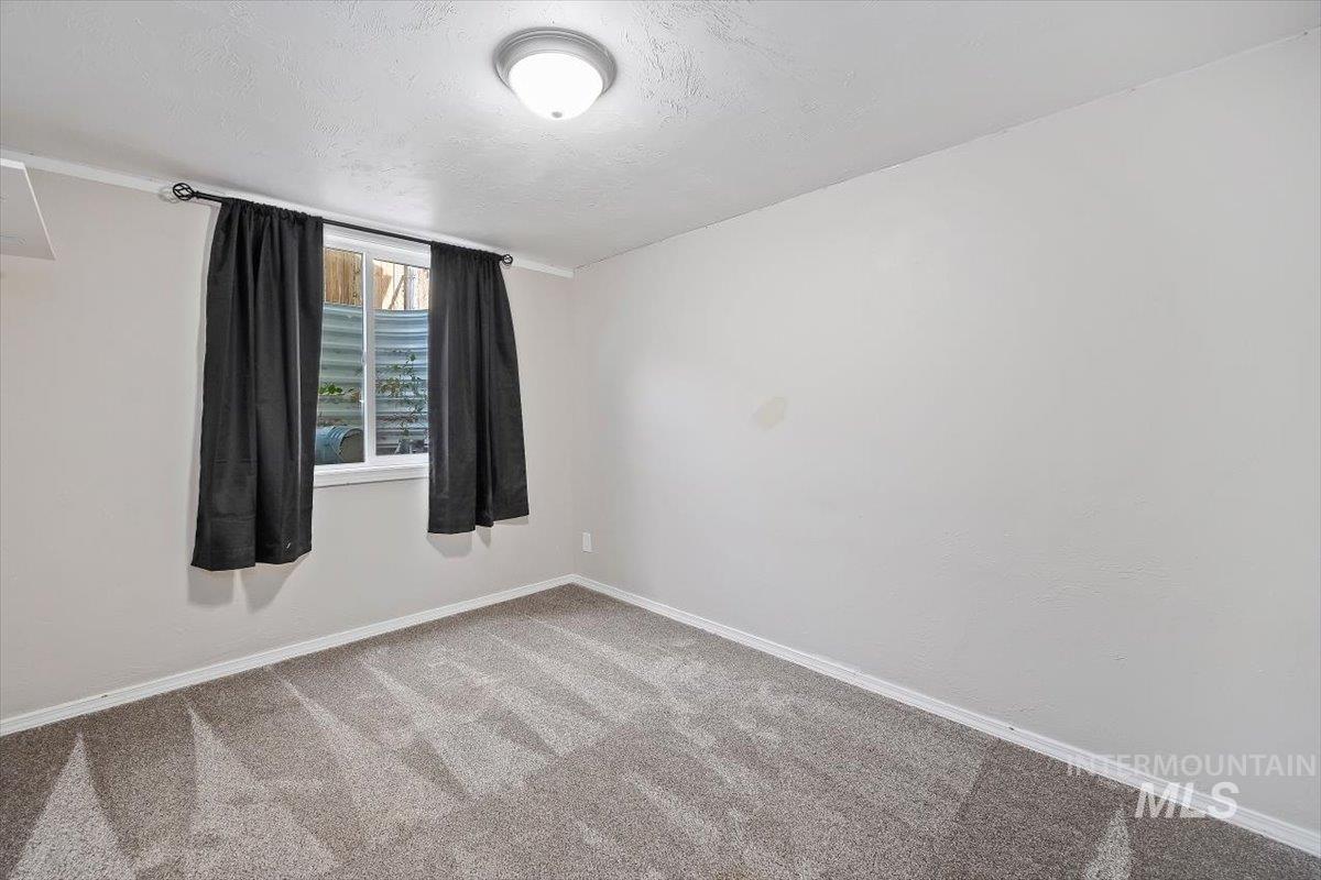 Spare room featuring carpet floors and a textured ceiling