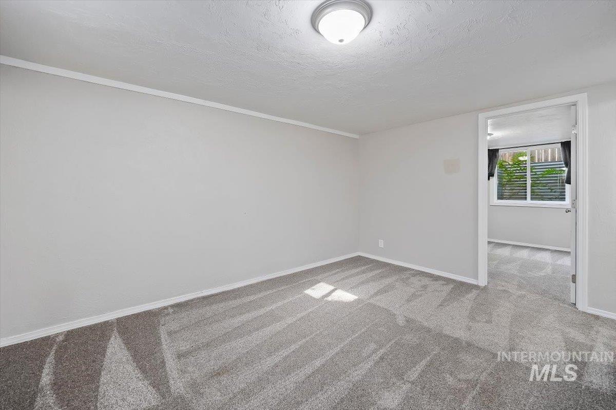 Unfurnished room with carpet floors and a textured ceiling