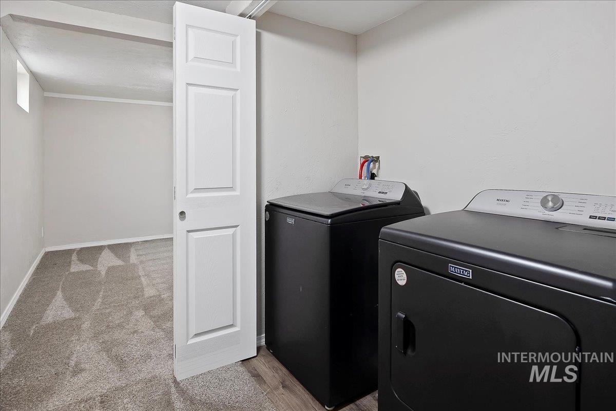 Laundry area with washer and clothes dryer and light carpet