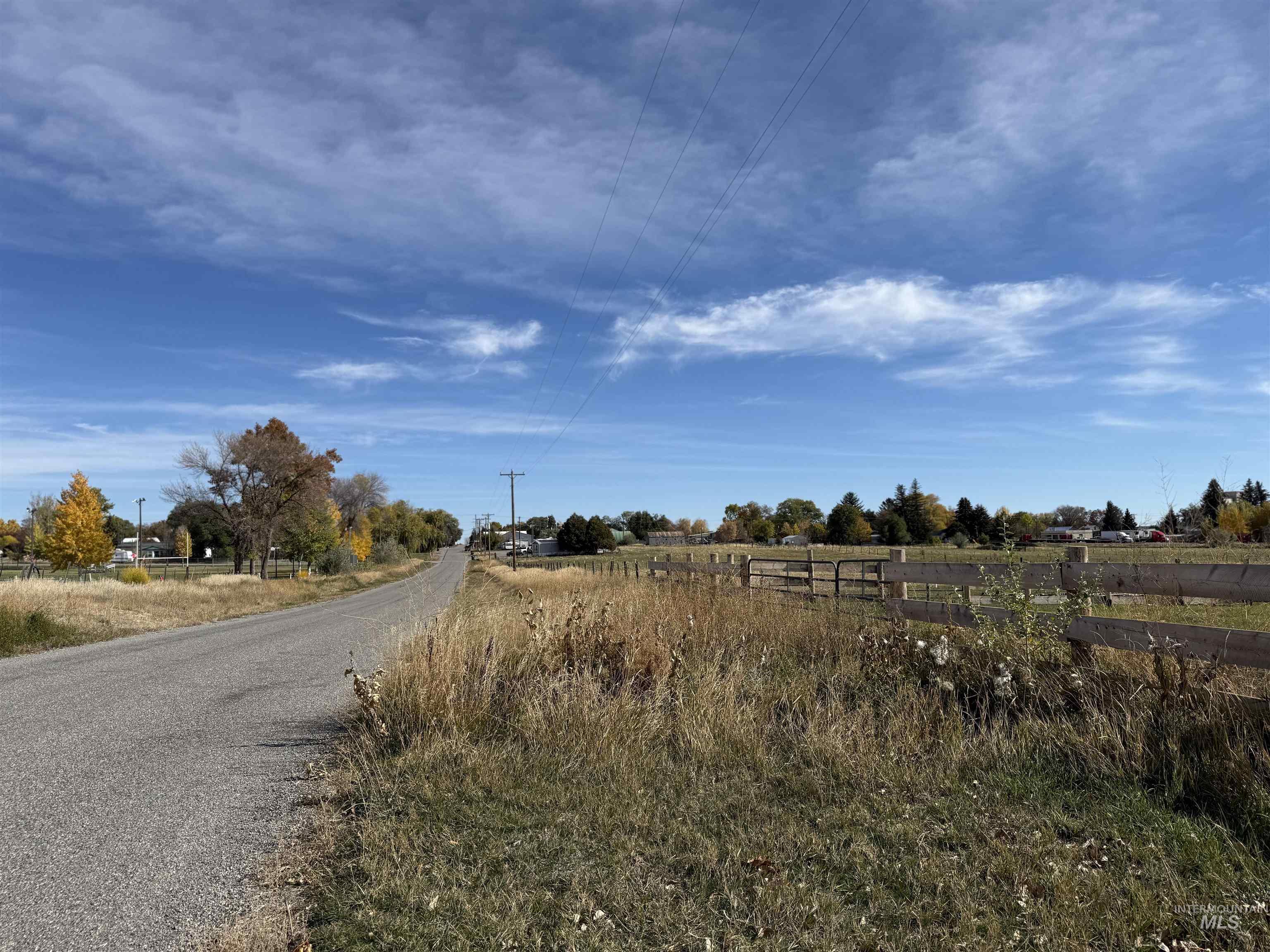 View of asphalt street featuring a view of rural / pastoral area