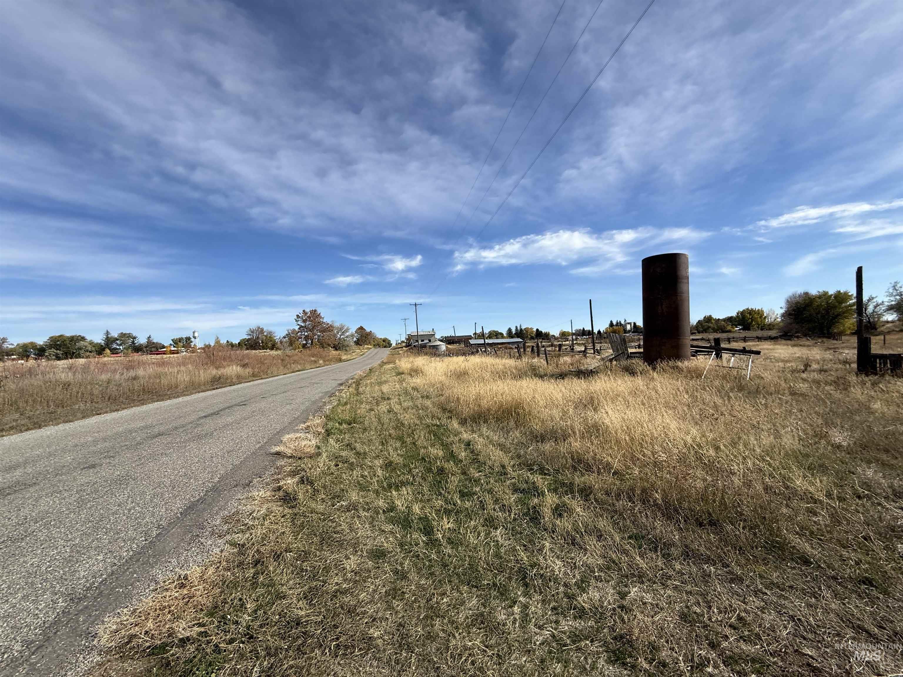 View of asphalt street featuring a view of rural / pastoral area