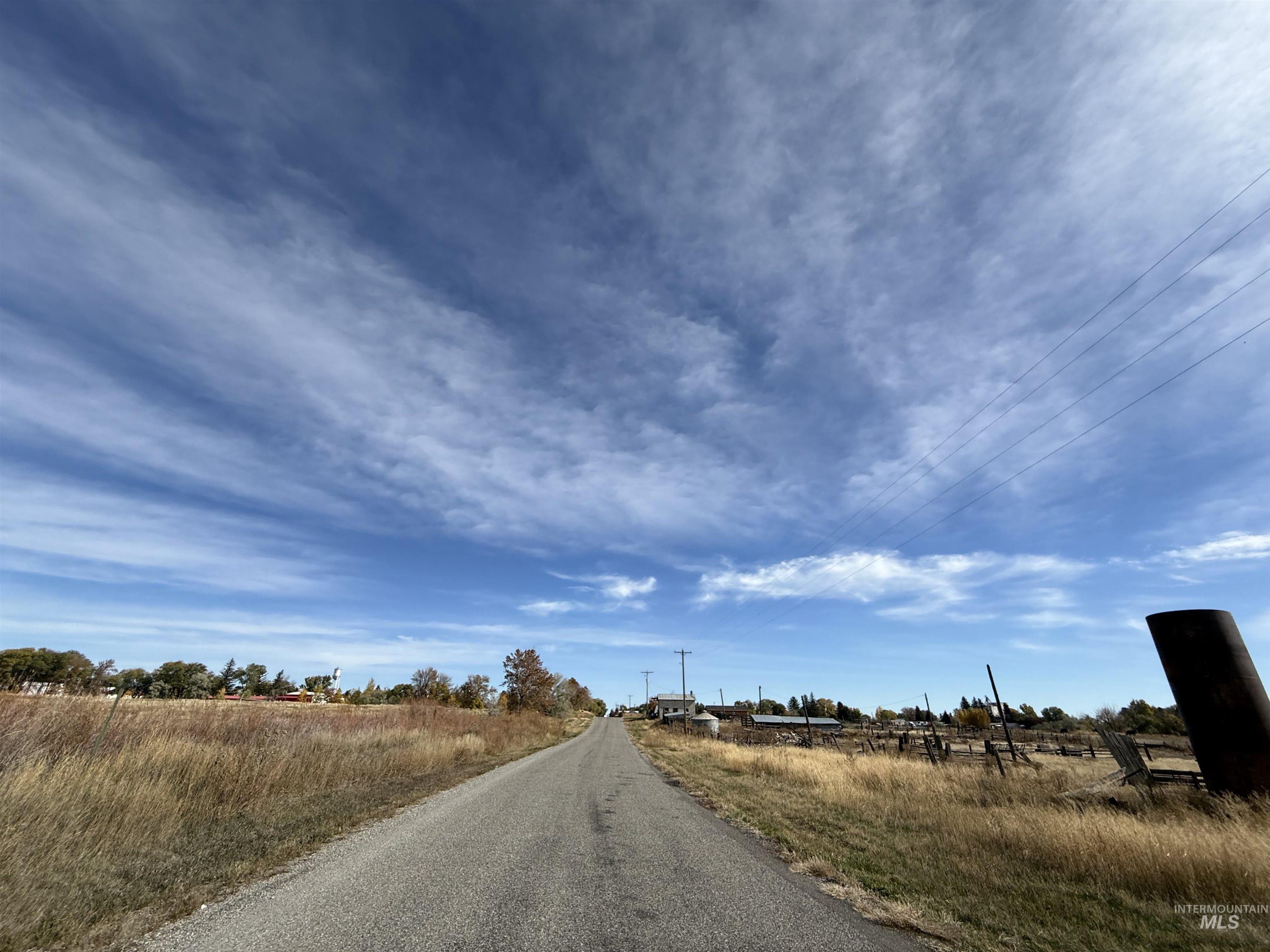 View of asphalt street with a rural view