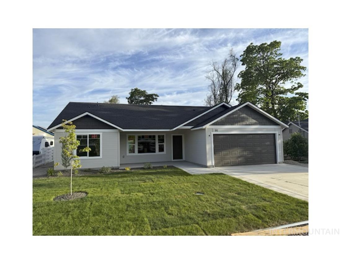 Ranch-style home featuring a garage, a front lawn, and concrete driveway