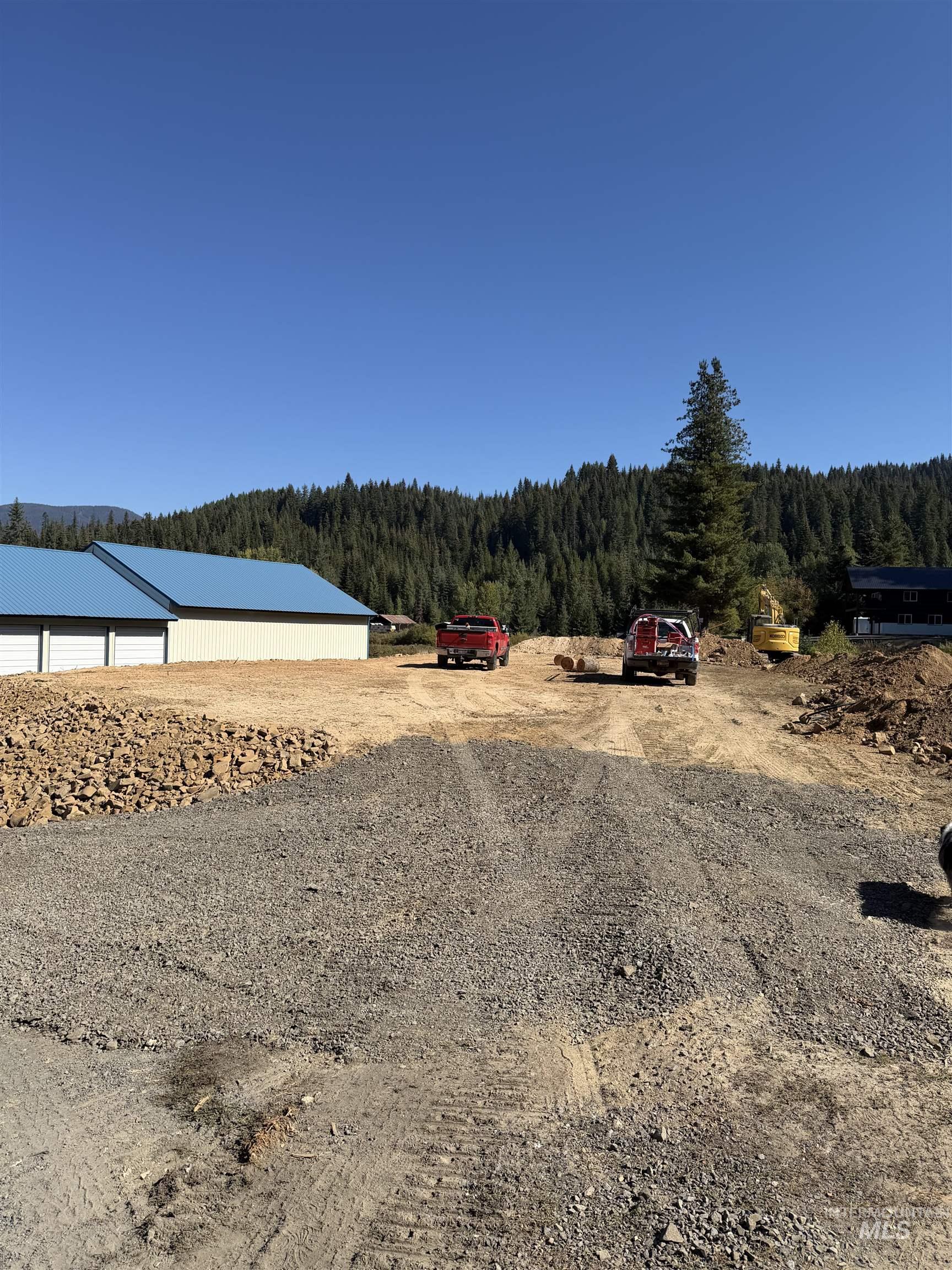 View of dirt / gravel driveway featuring a wooded view