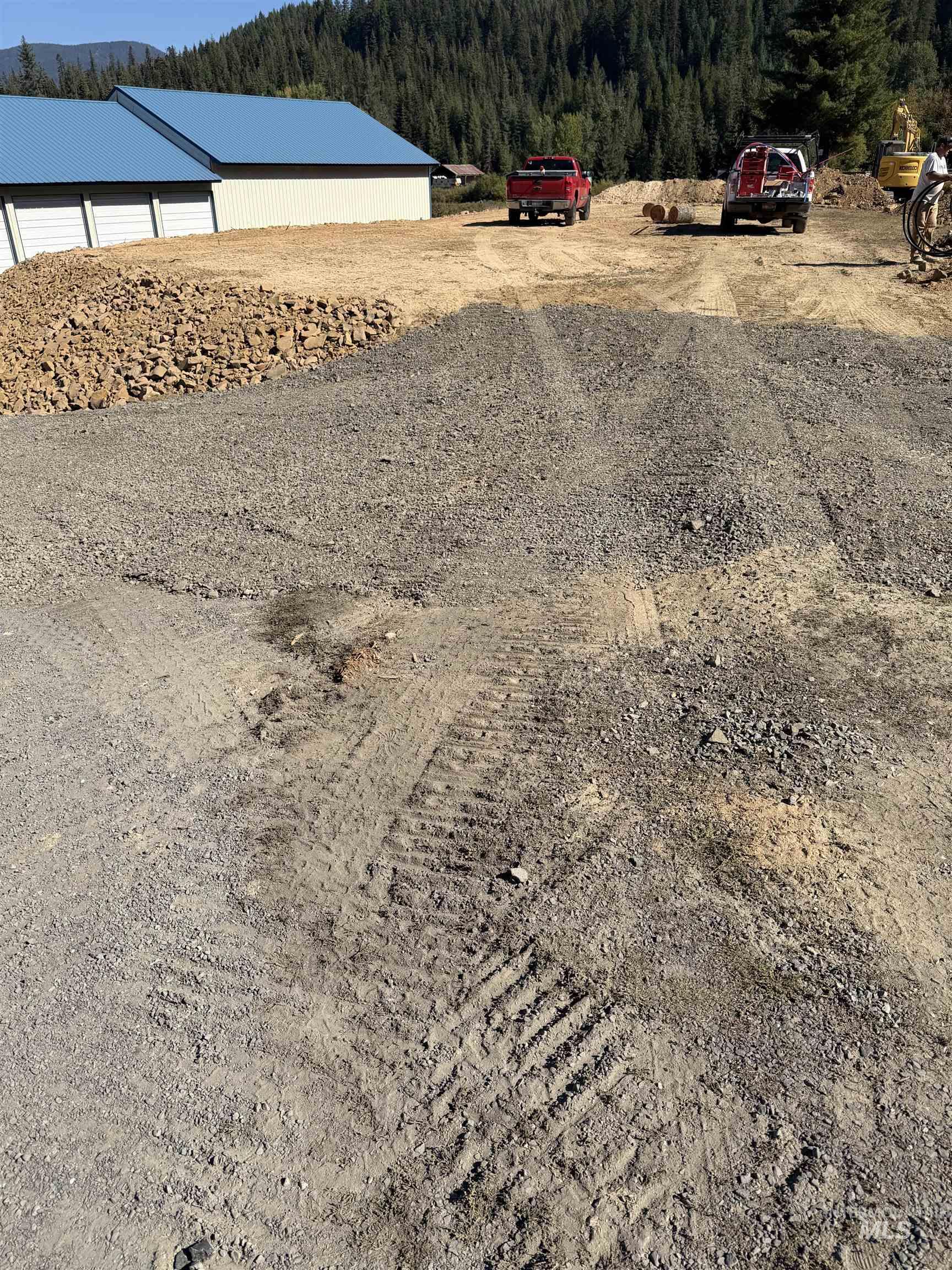 View of yard with a wooded view, an outdoor structure, and a pole building