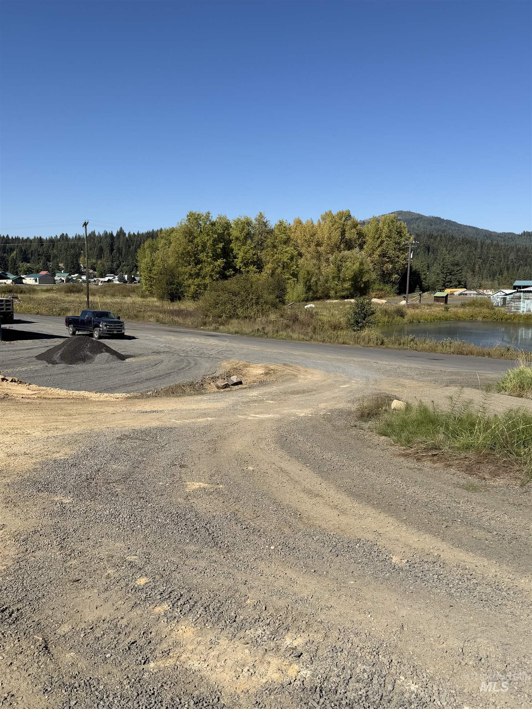 View of dirt / gravel road with a wooded view