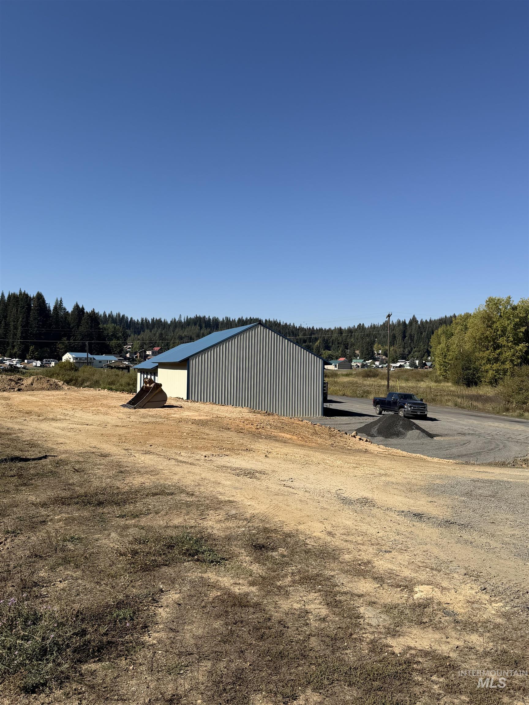 View of yard with a pole building, an outbuilding, and a wooded view