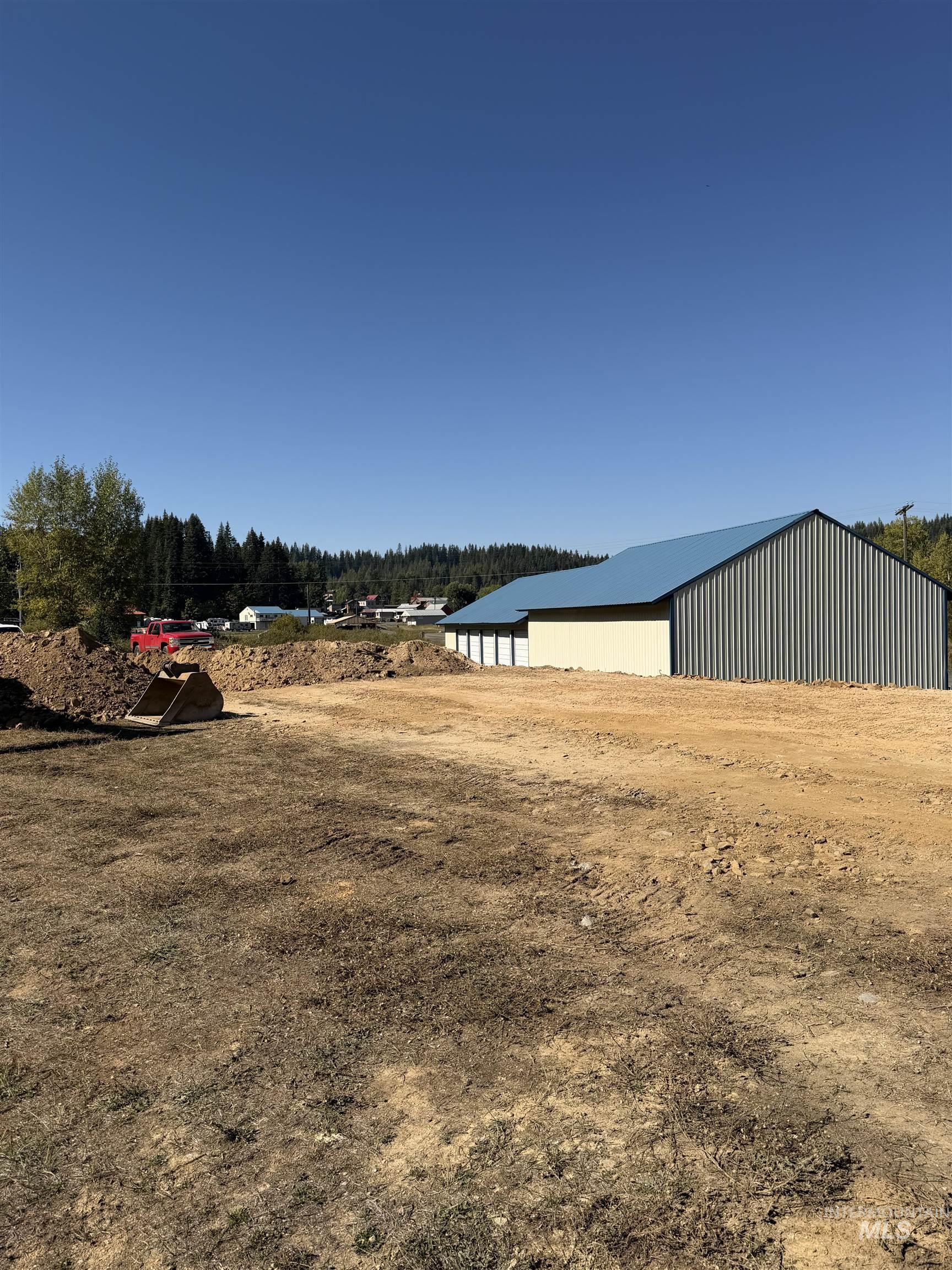 View of yard featuring a pole building, an outbuilding, and a forest view