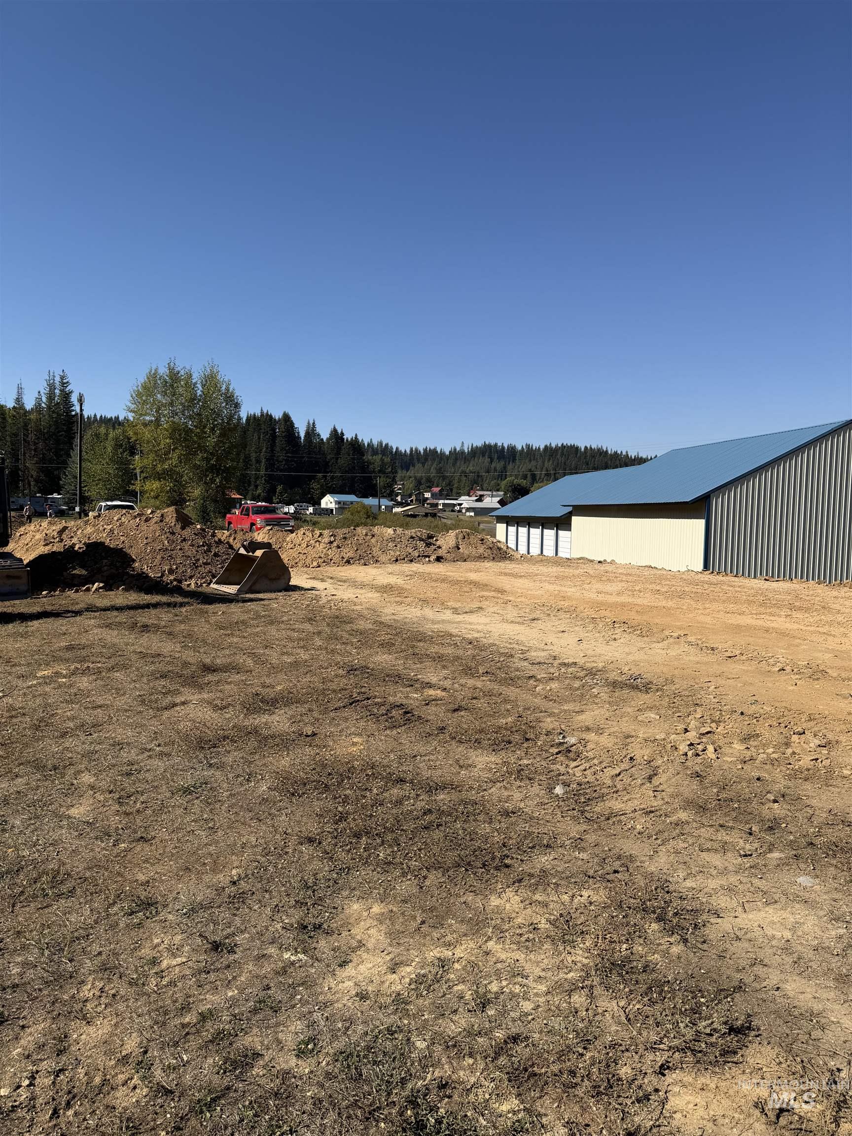 View of yard featuring a pole building, an outdoor structure, and a forest view