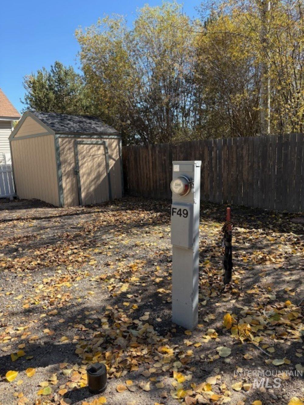 Fenced backyard featuring a shed