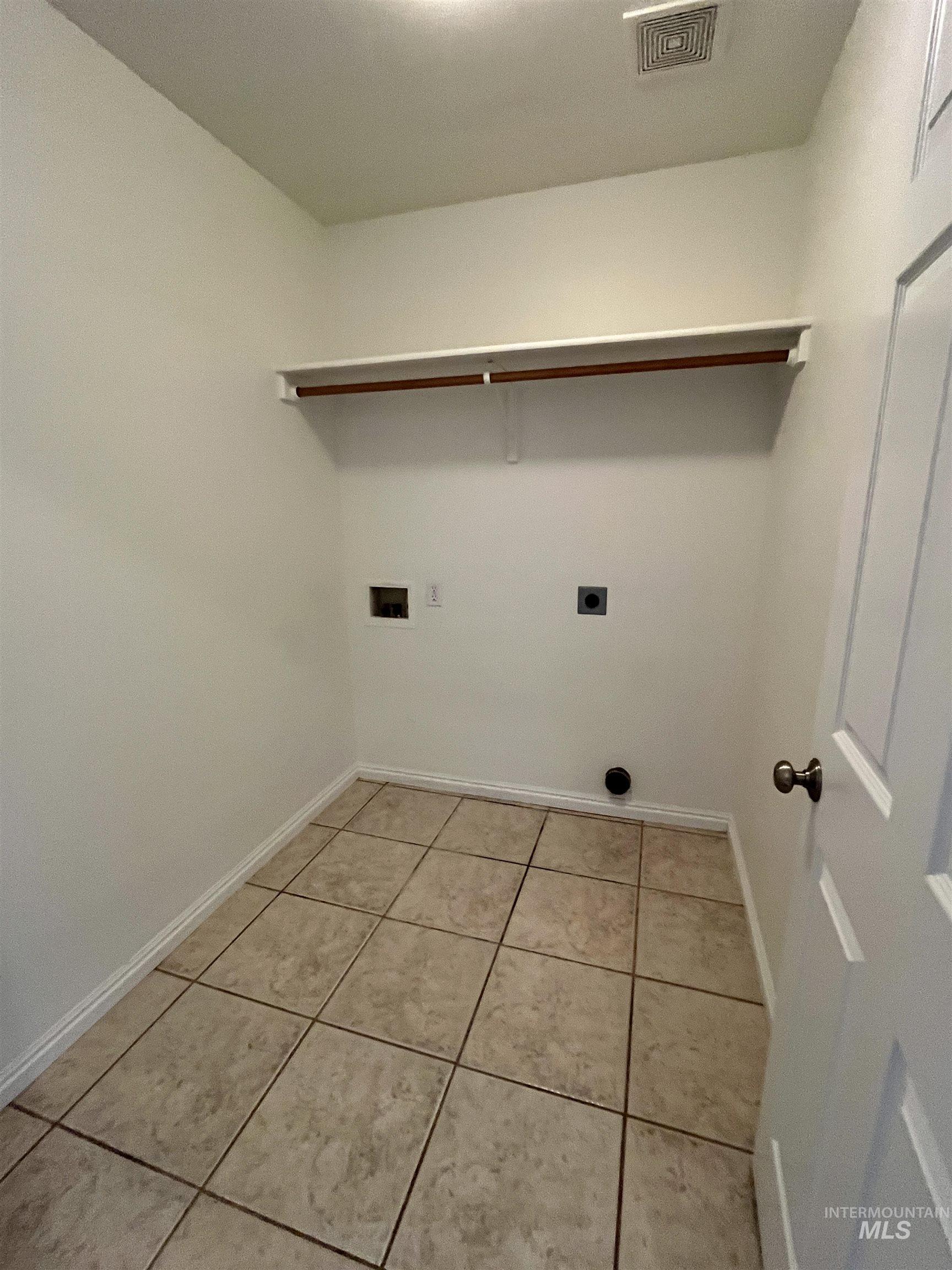 Washroom with light tile patterned floors, washer hookup, and electric dryer hookup
