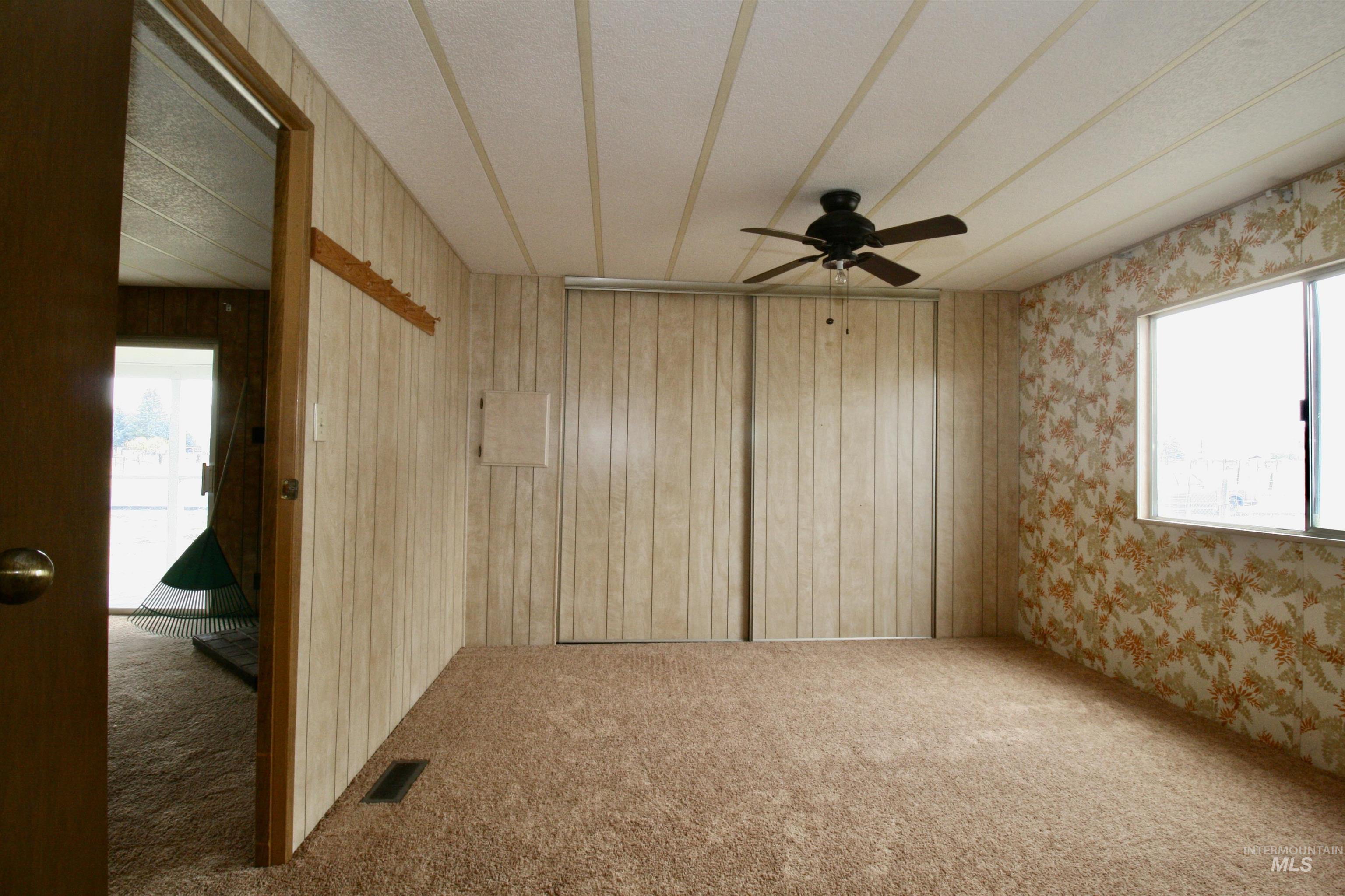 Carpeted spare room featuring a ceiling fan