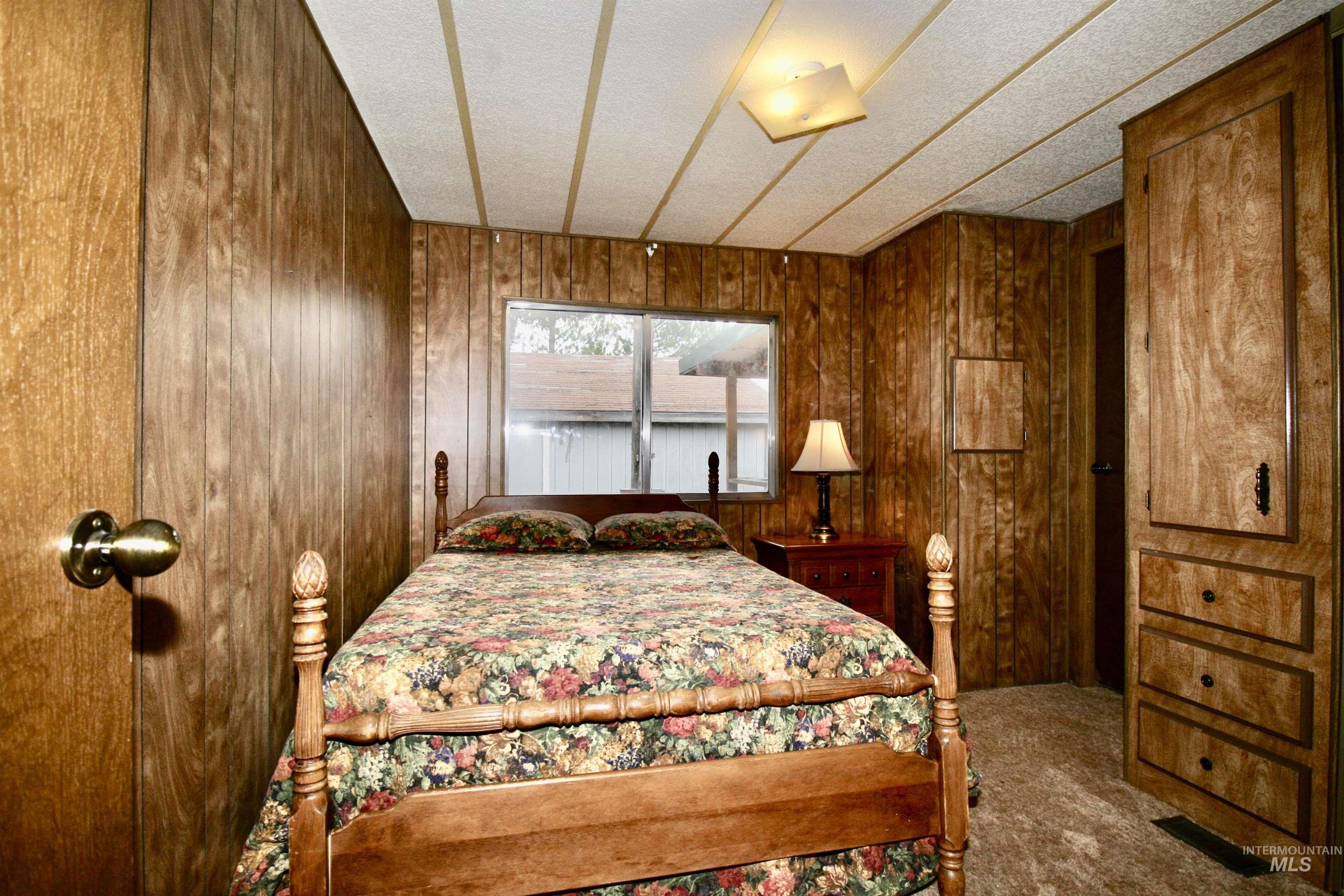 Bedroom featuring carpet and wooden walls