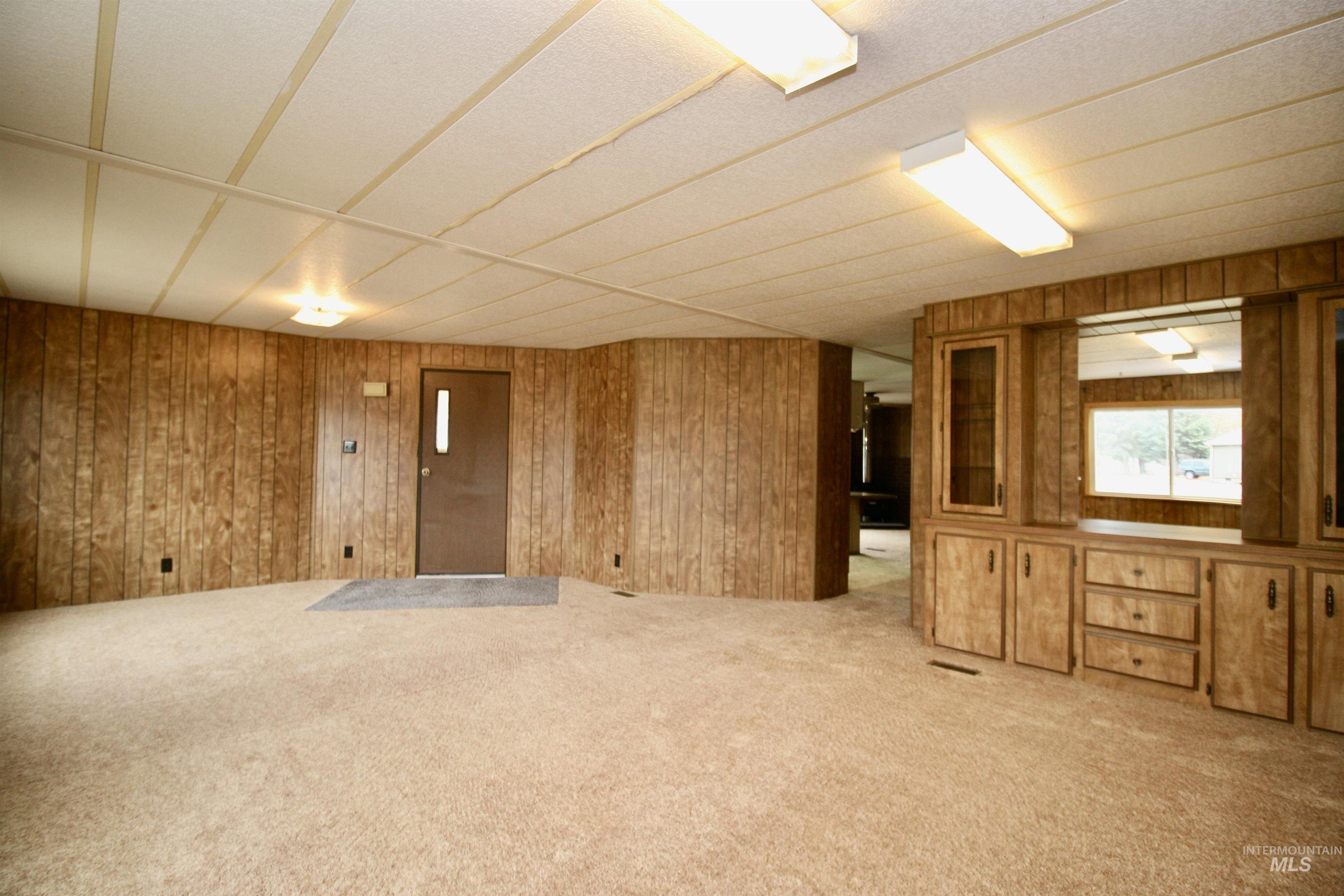 Carpeted empty room with wood walls