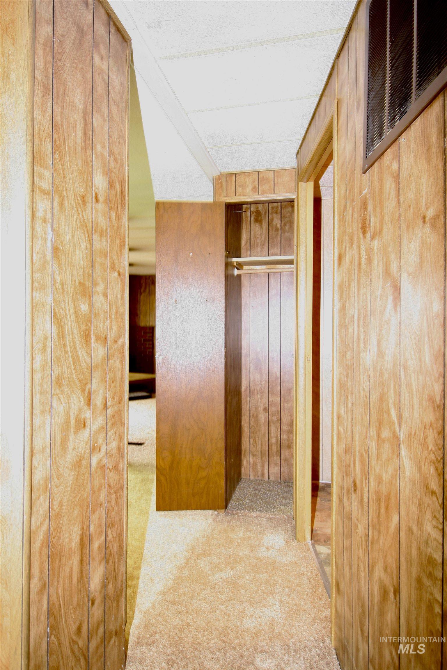 Corridor with light colored carpet and wood walls