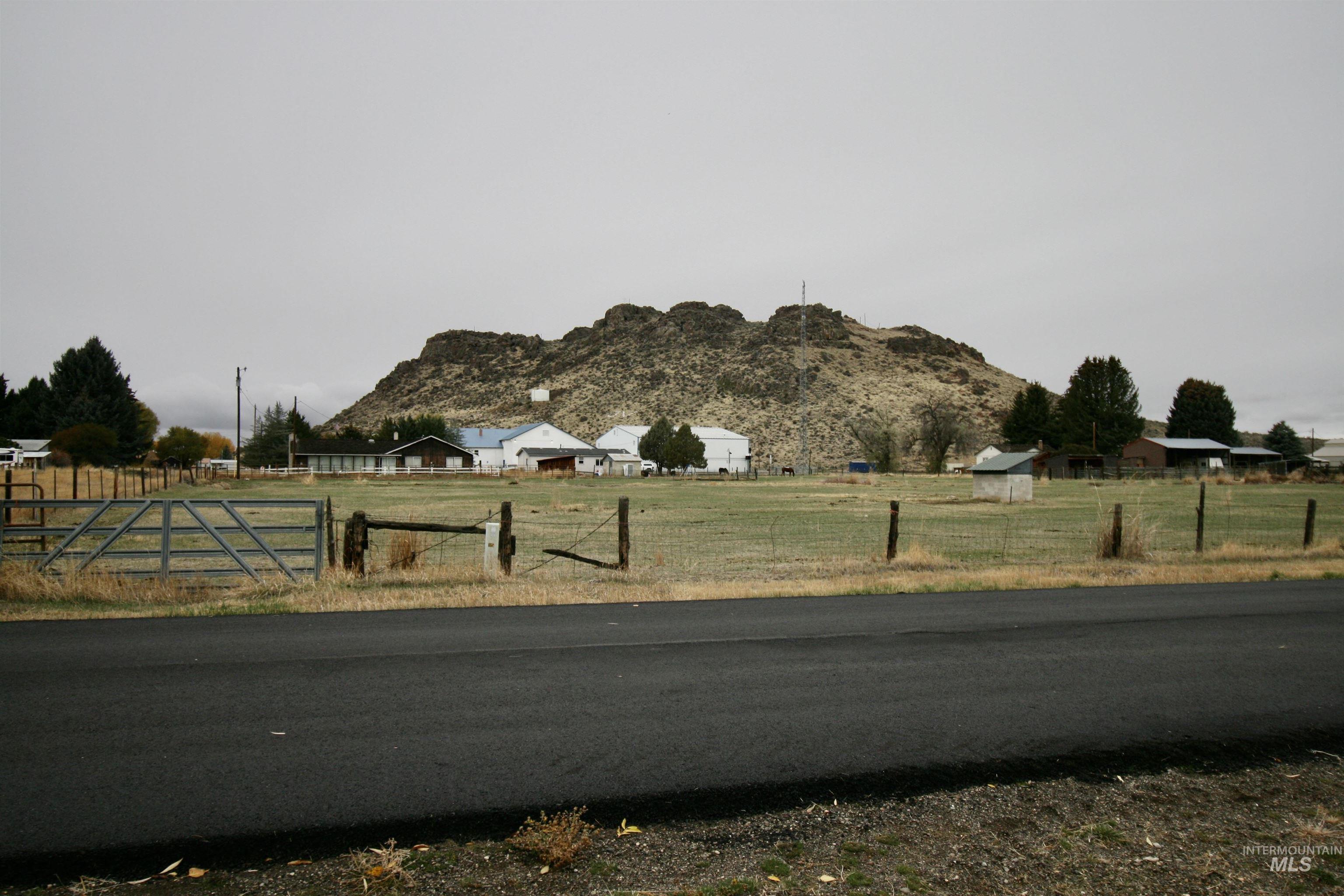 View of asphalt road with a view of rural / pastoral area and a mountain view