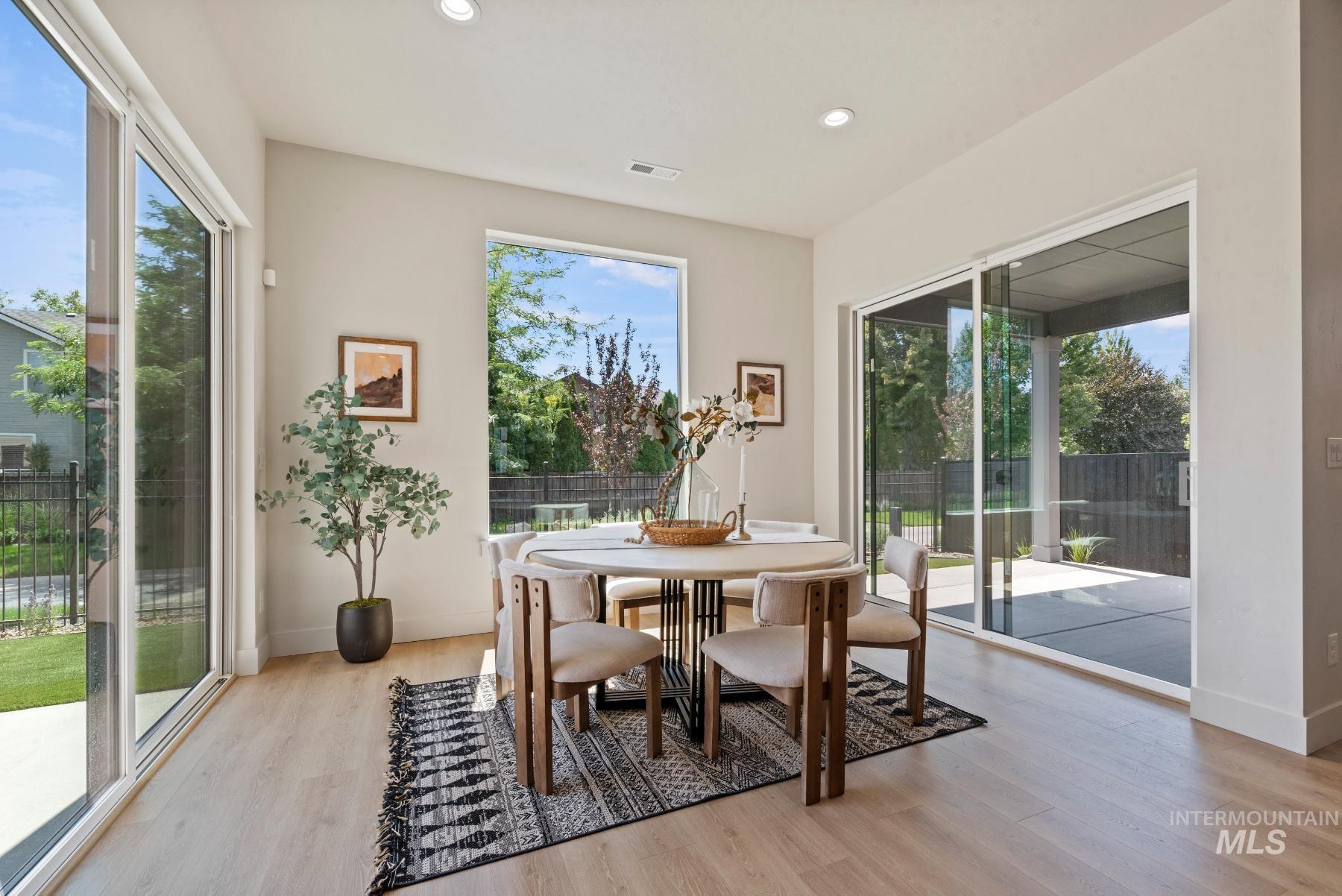 Dining space with light wood finished floors and recessed lighting