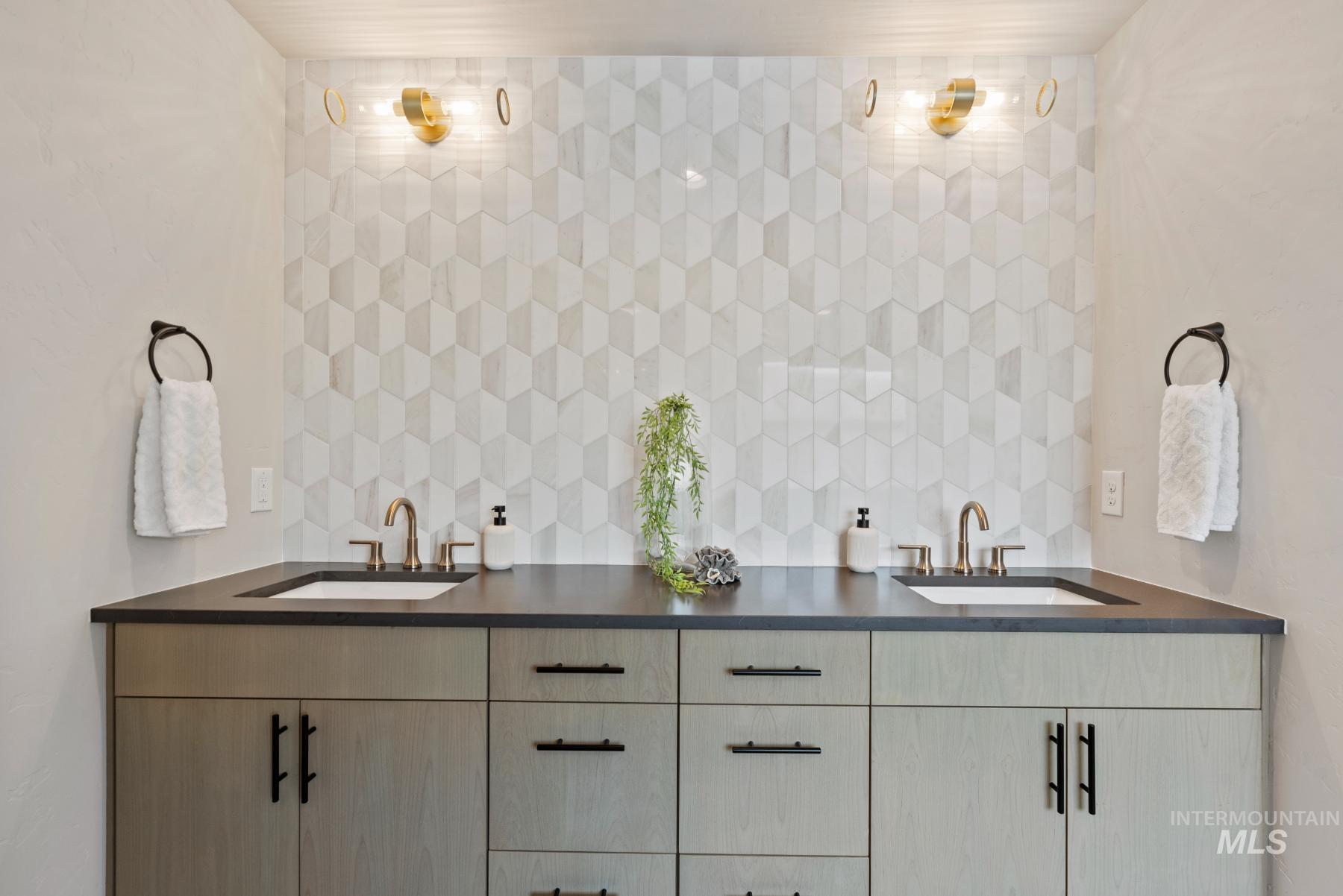 Full bathroom featuring double vanity and tasteful backsplash