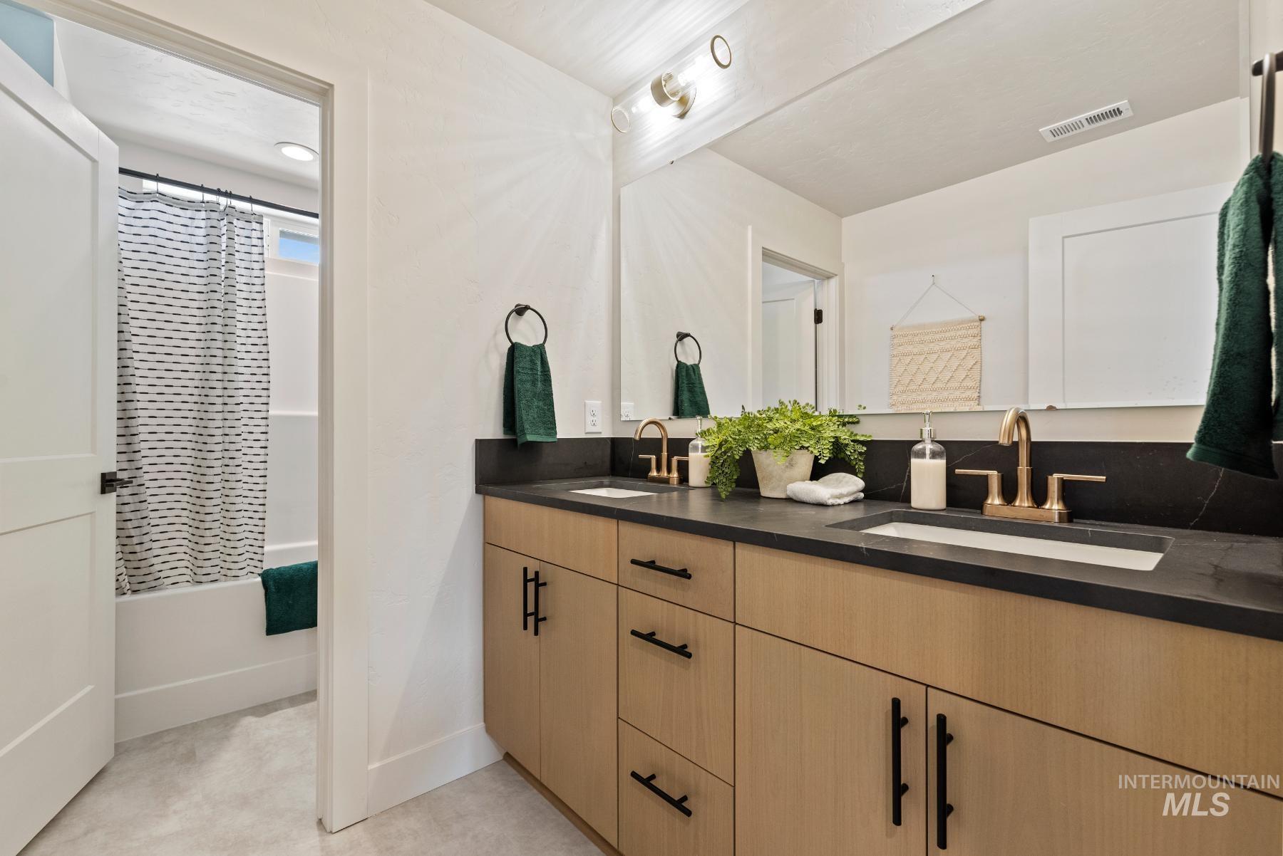 Bathroom with shower / tub combo and double vanity