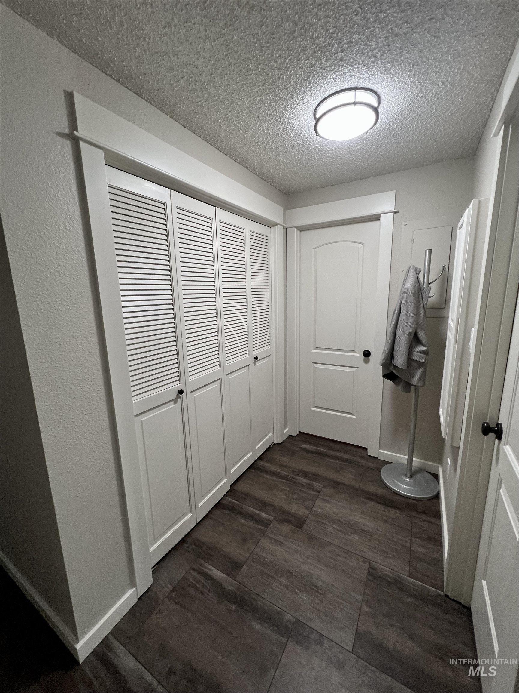 Corridor with a textured ceiling and a textured wall
