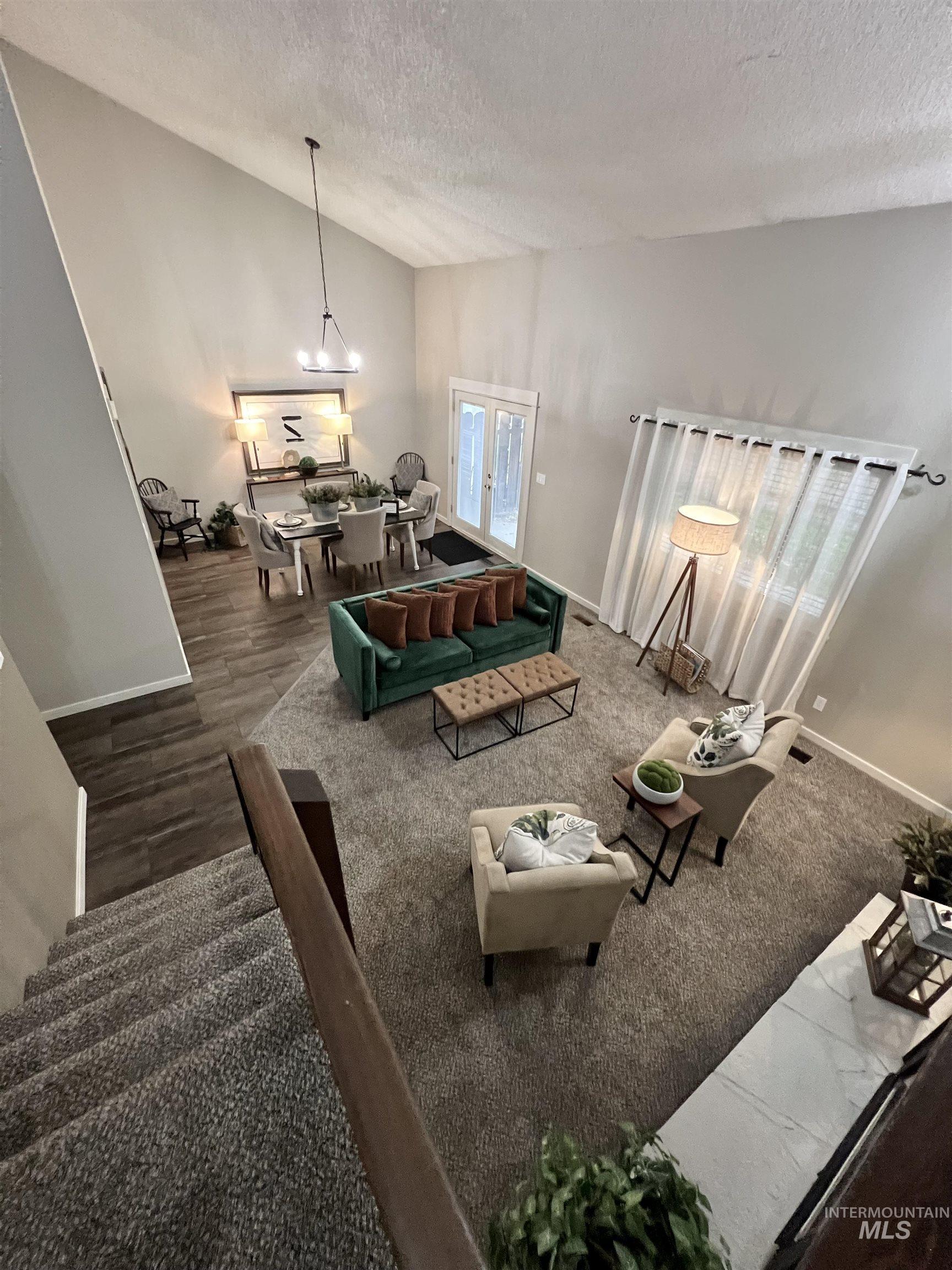 Living room featuring a textured ceiling, wood finished floors, and high vaulted ceiling