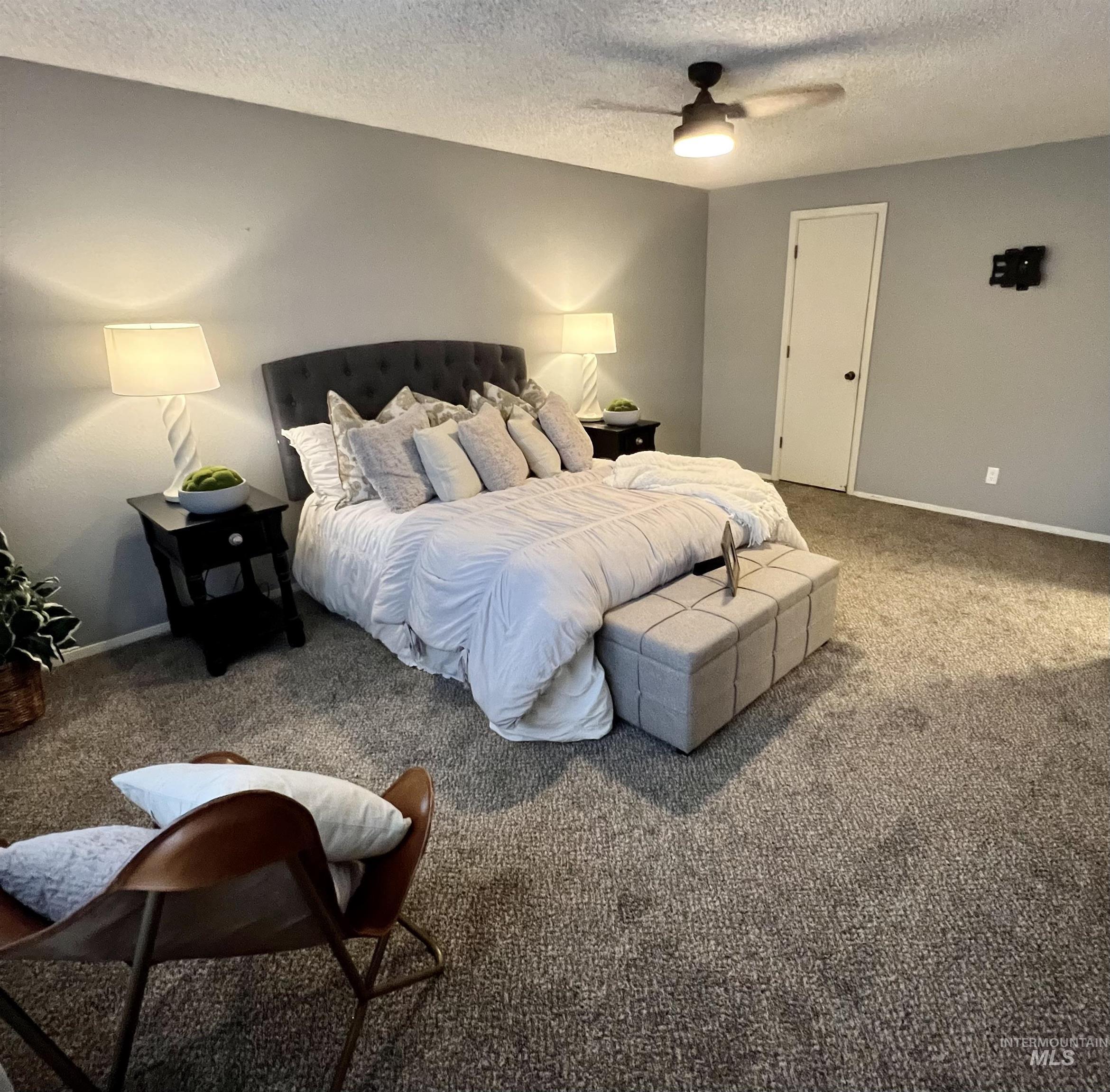 Bedroom featuring a textured ceiling, carpet, and ceiling fan