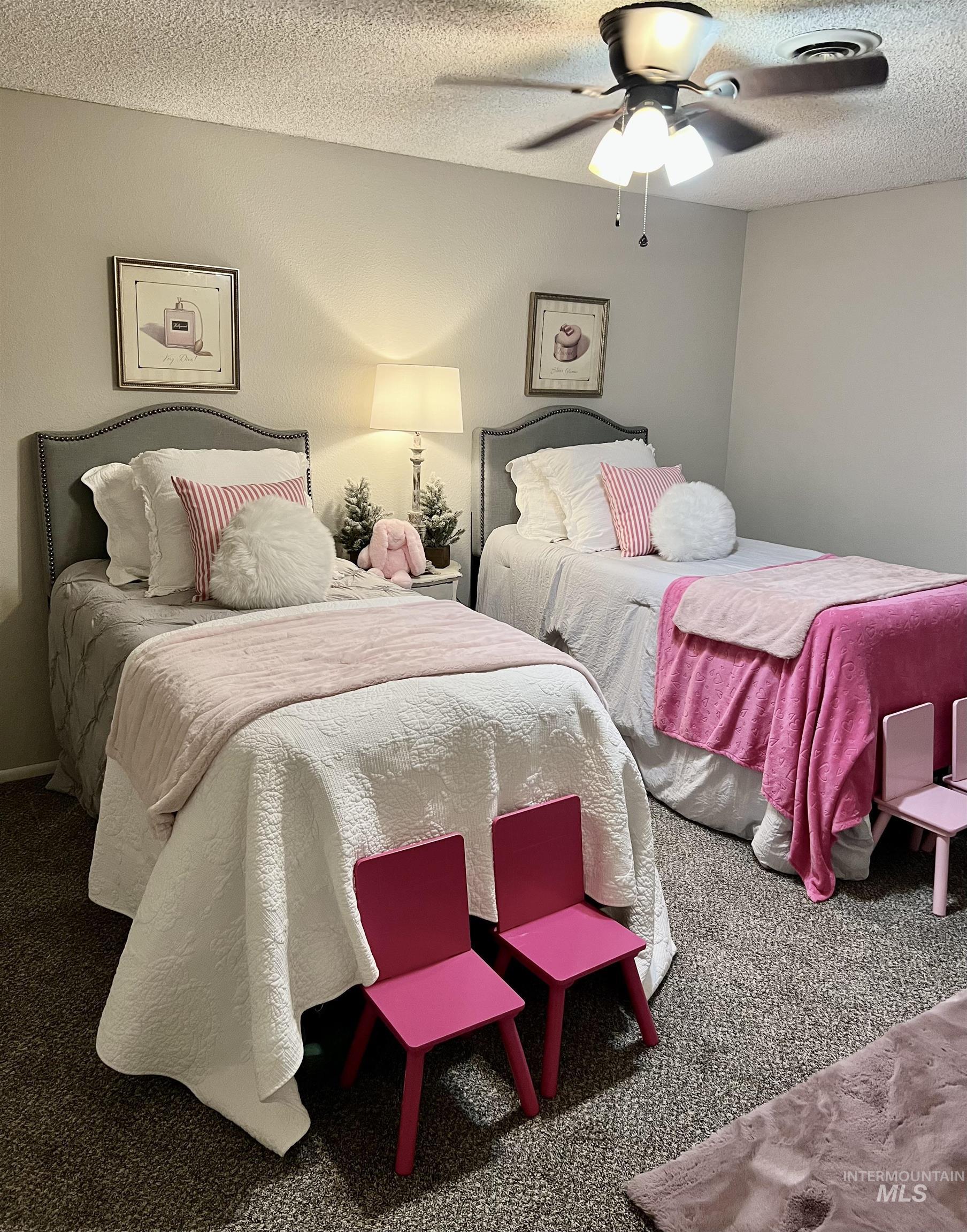 Carpeted bedroom featuring a textured ceiling and ceiling fan