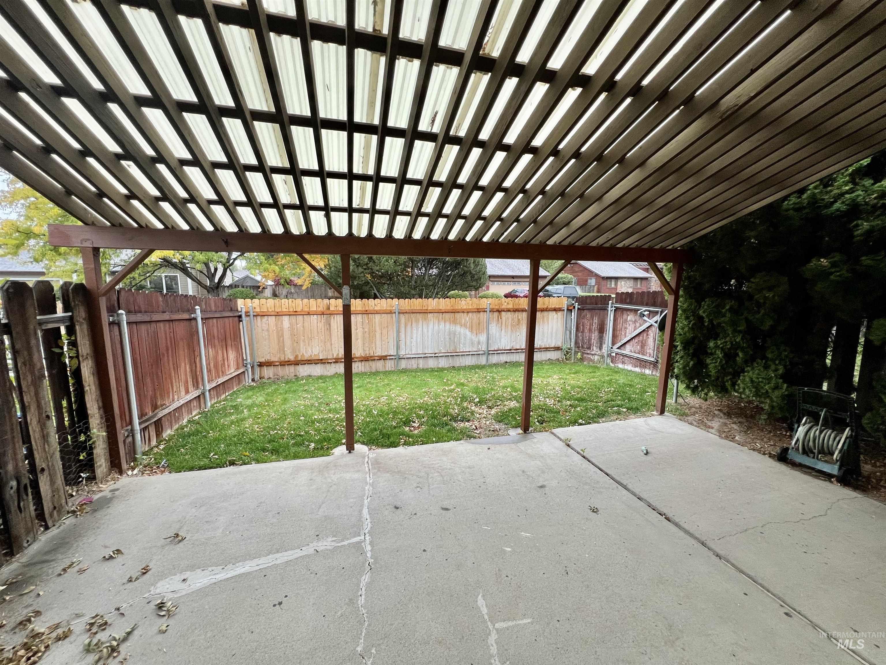 Fenced backyard with a pergola and a patio