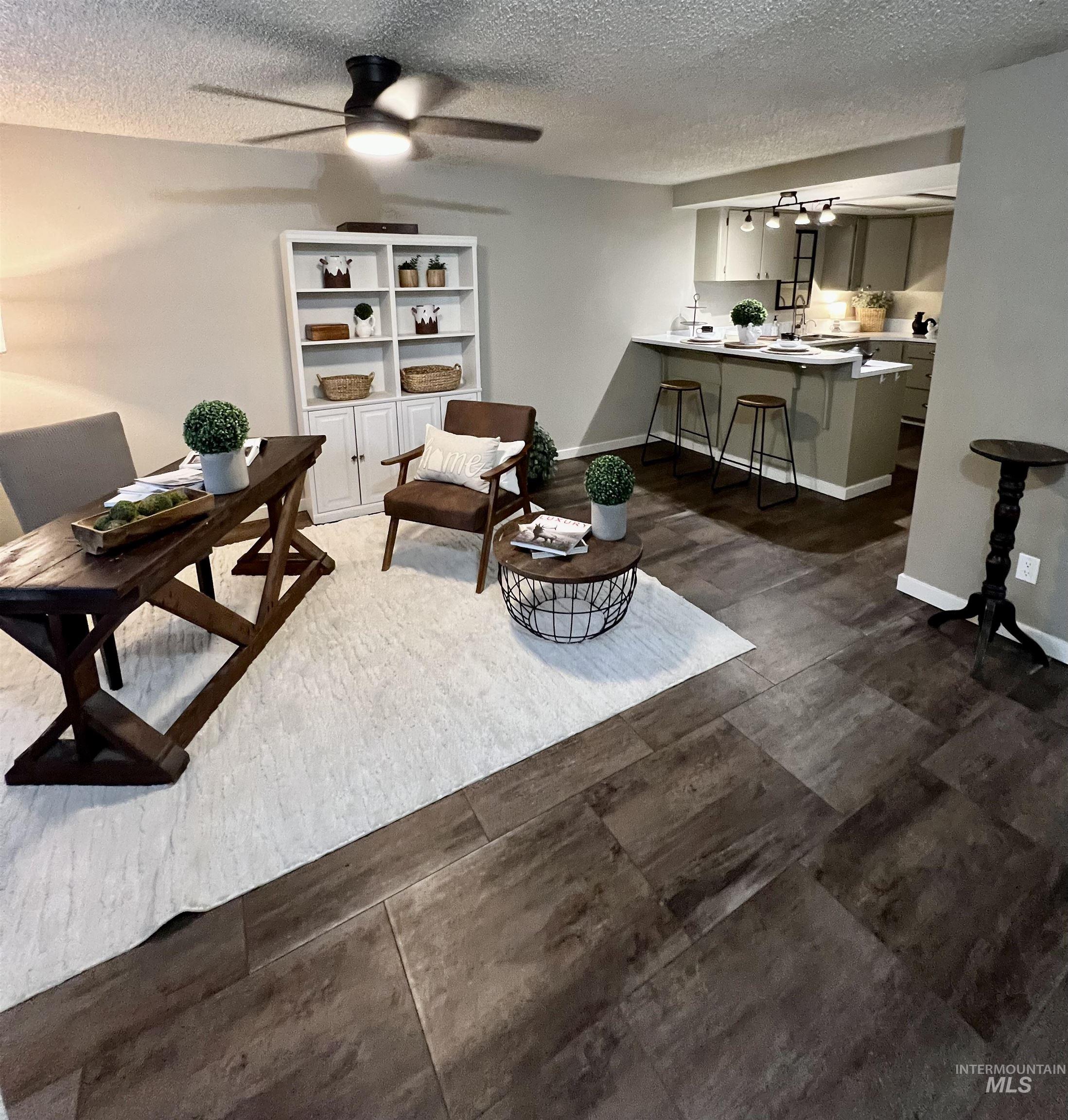 Living room with a textured ceiling and a ceiling fan