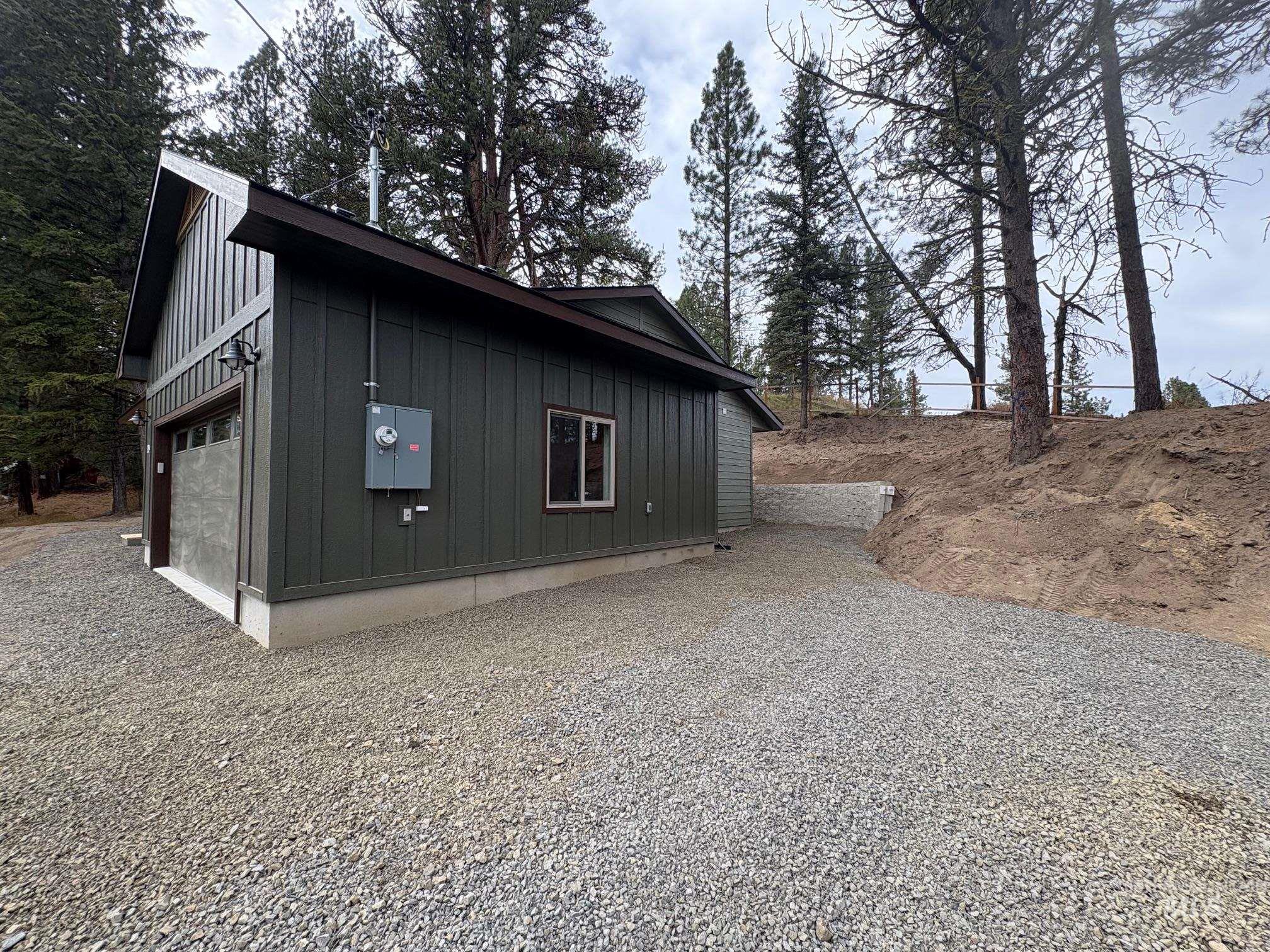 View of home's exterior featuring a garage, board and batten siding, and driveway