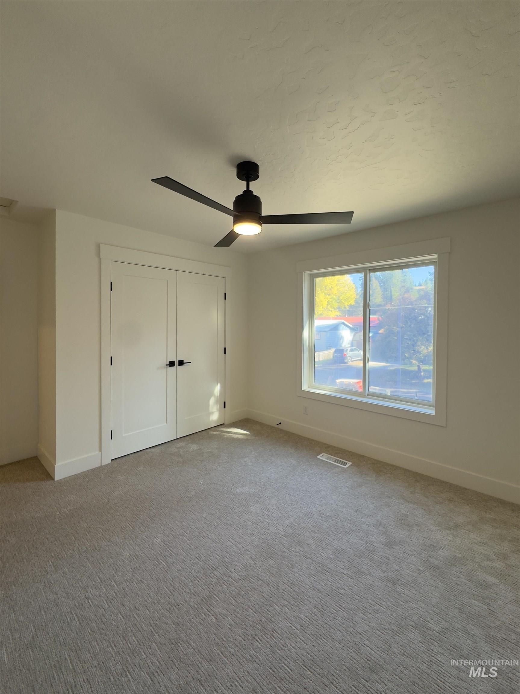 Unfurnished bedroom with a closet, light carpet, and a ceiling fan