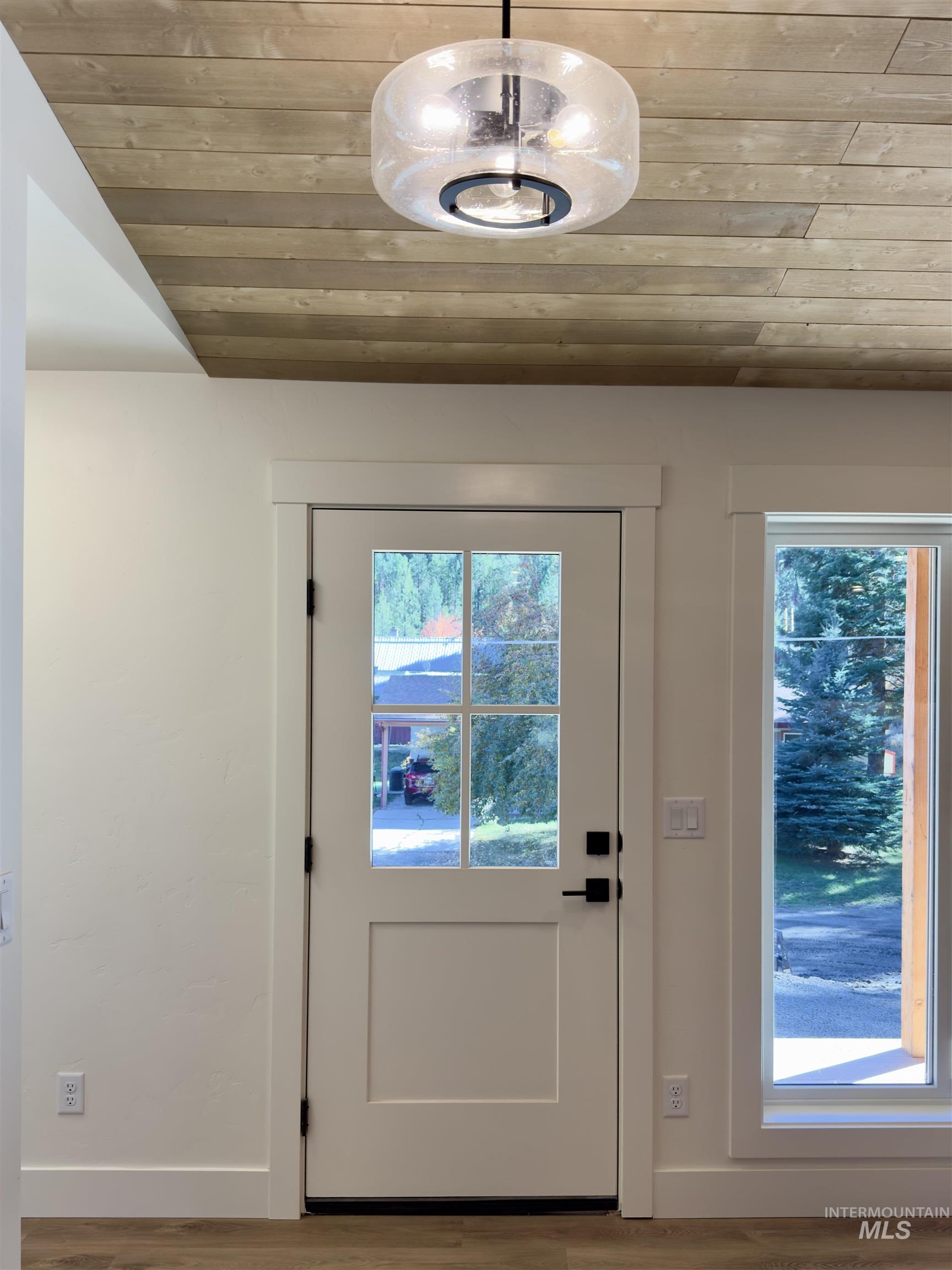 Entryway featuring wooden ceiling, plenty of natural light, and wood finished floors