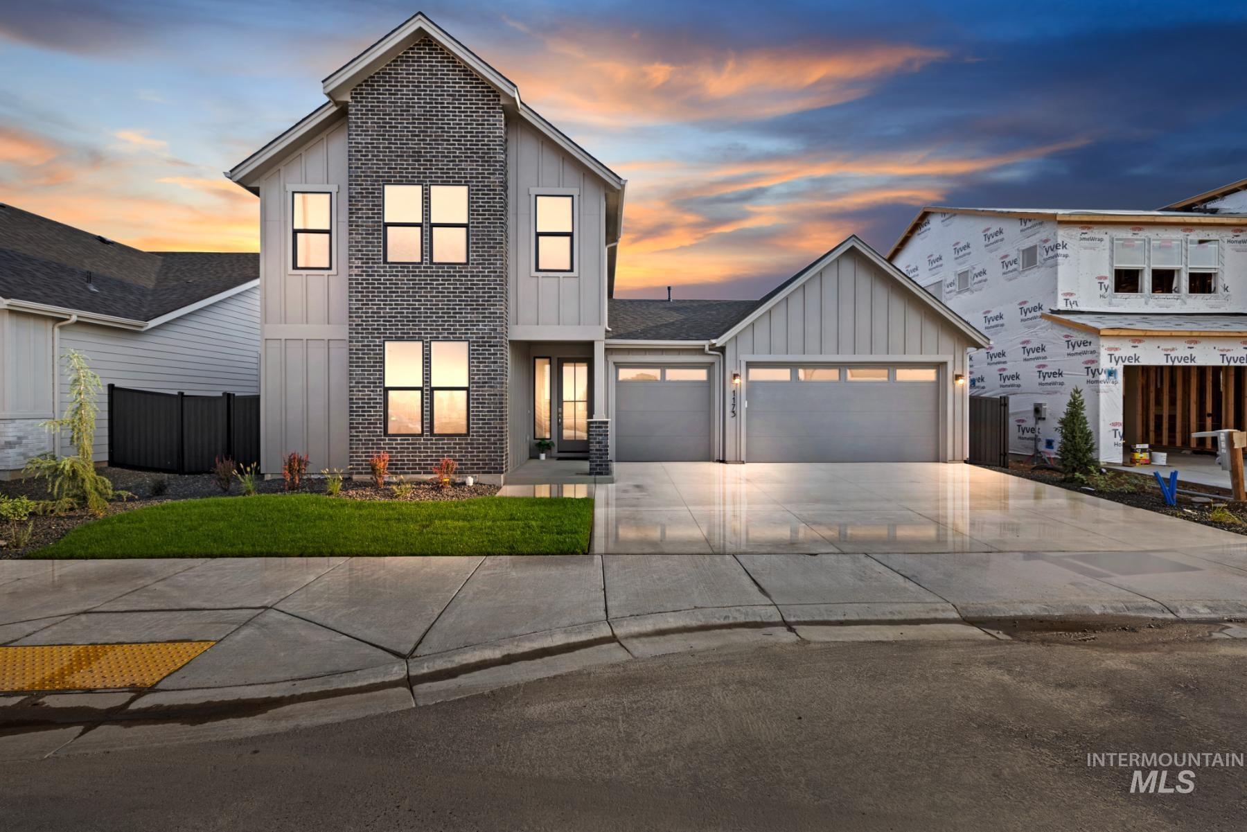 View of front of home featuring board and batten siding, a garage, and concrete driveway