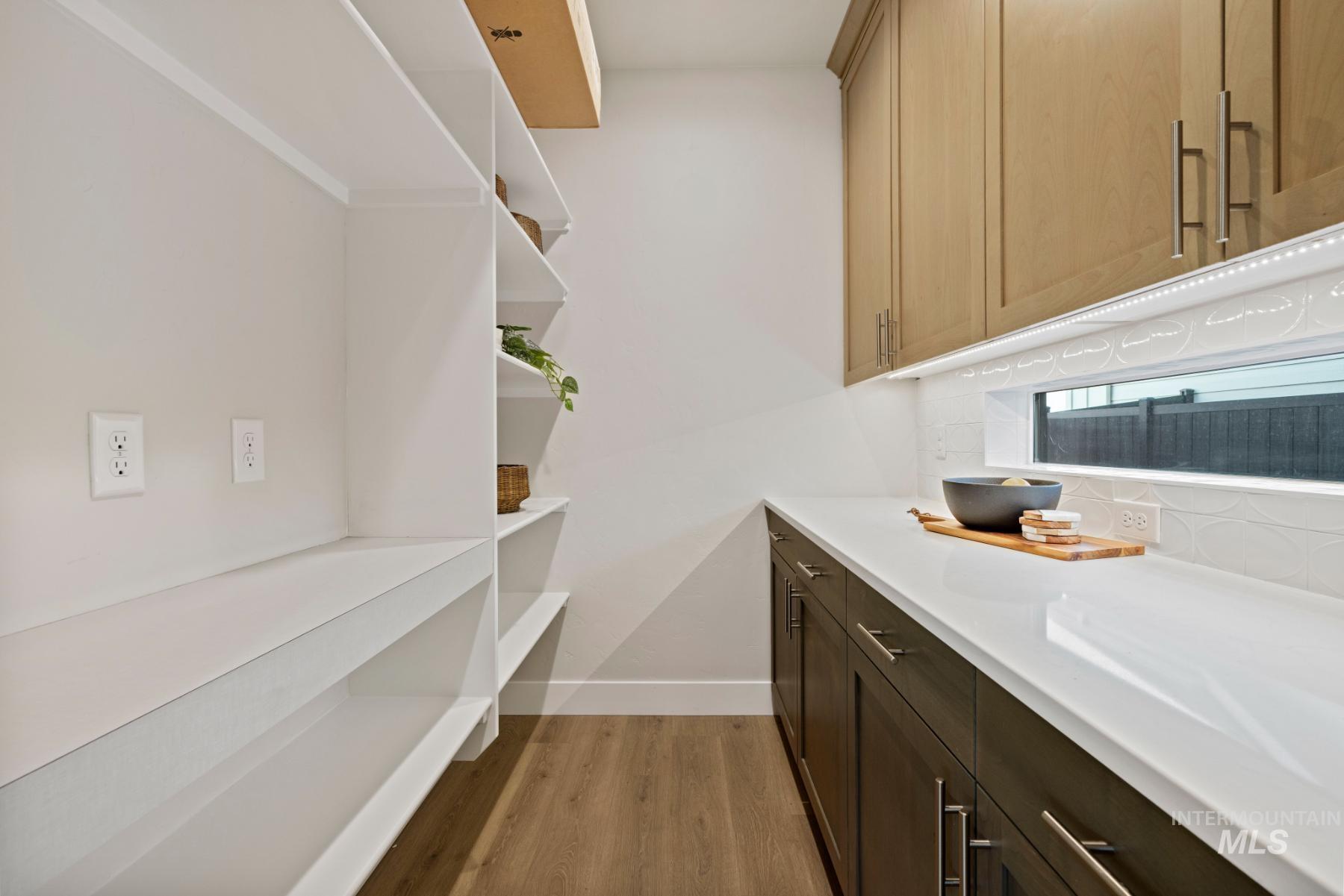 Laundry area featuring light wood finished floors and baseboards