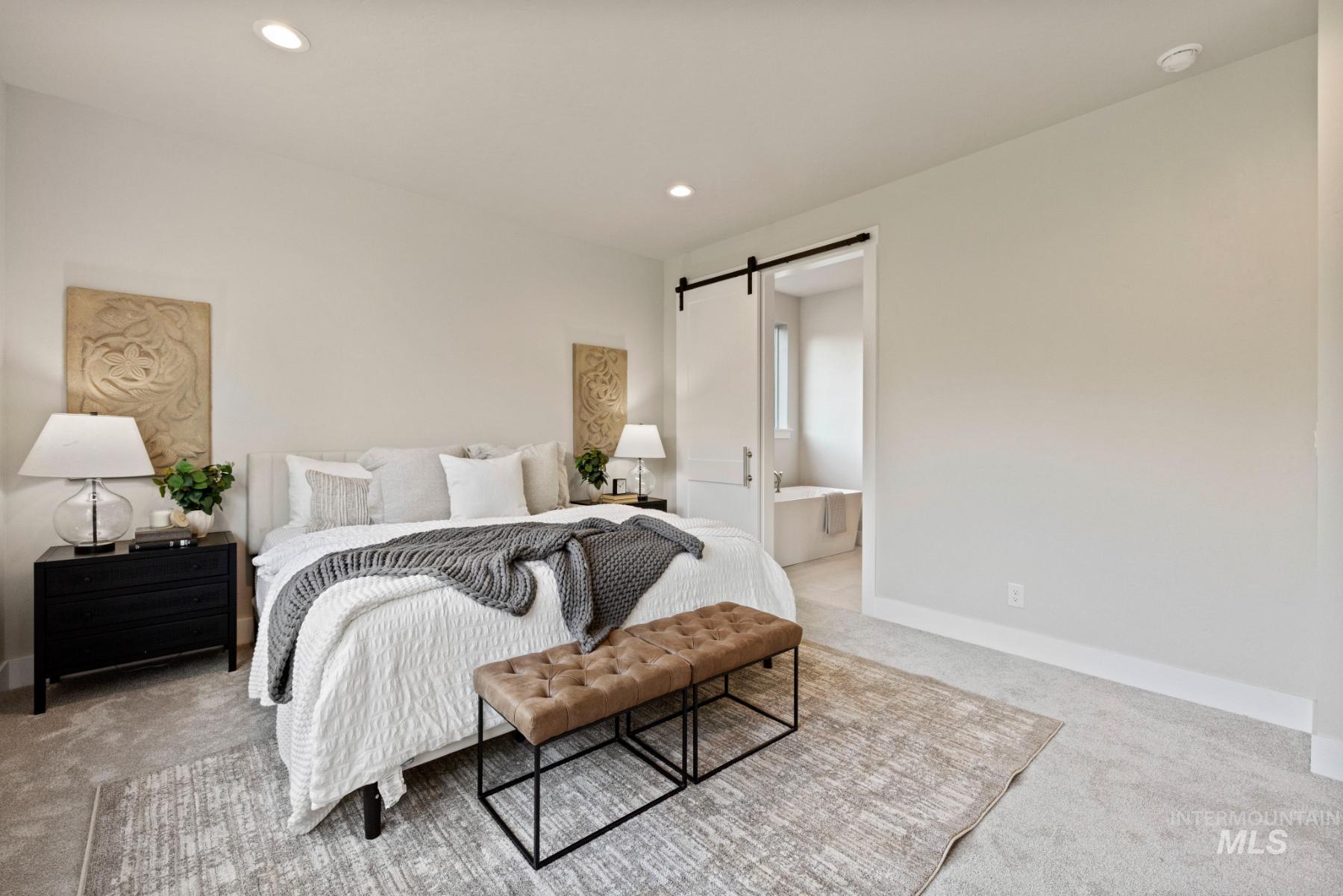 Bedroom with a barn door, carpet floors, recessed lighting, and connected bathroom